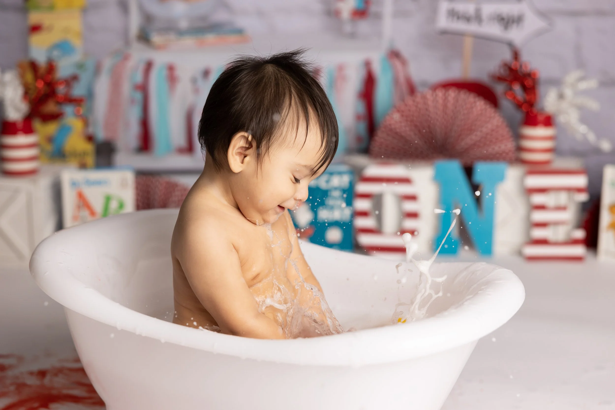 Cake smash bath photo – Cat in the Hat theme first birthday cleanup
