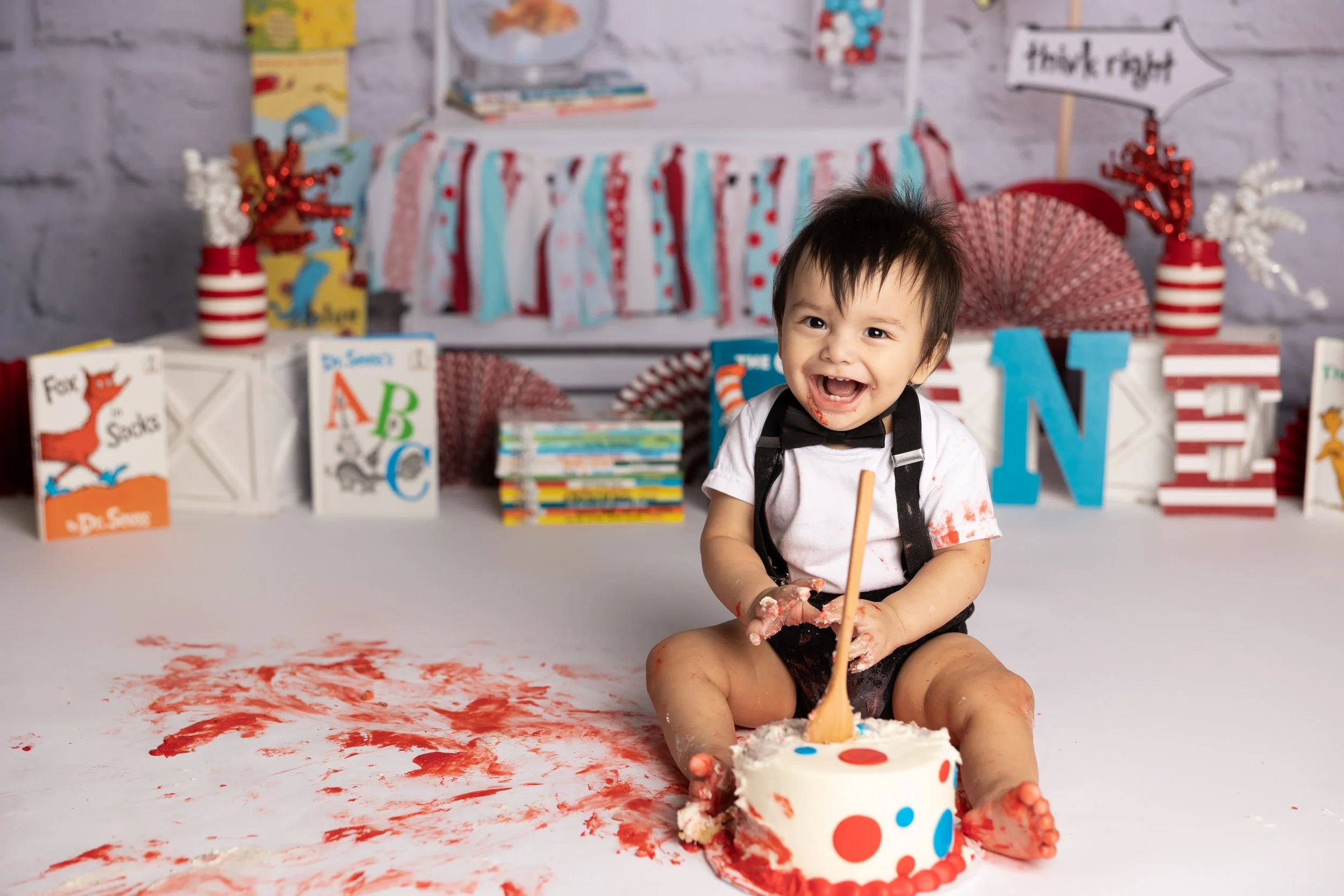 Cat in the Hat cake smash – first birthday boy smashing cake with red and blue setup