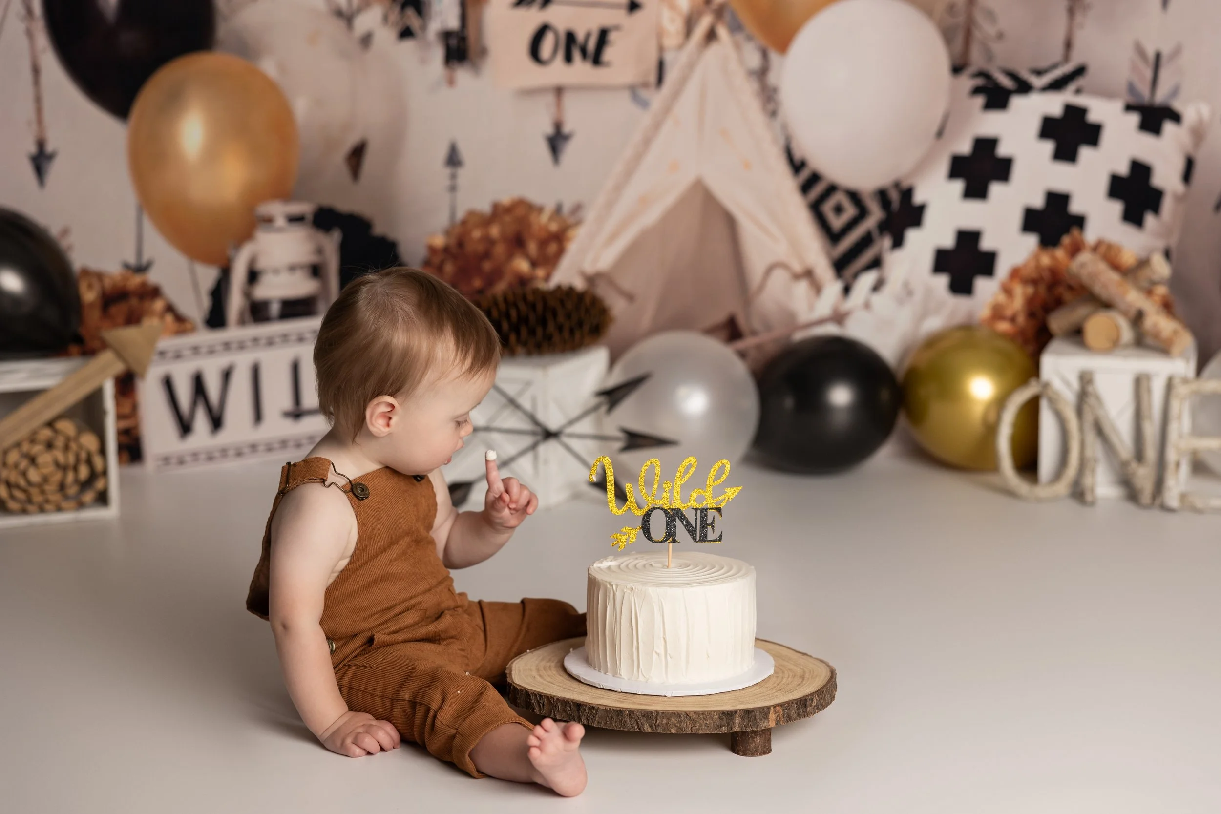Wild One cake smash – first birthday boy with simple white cake and black and gold decor