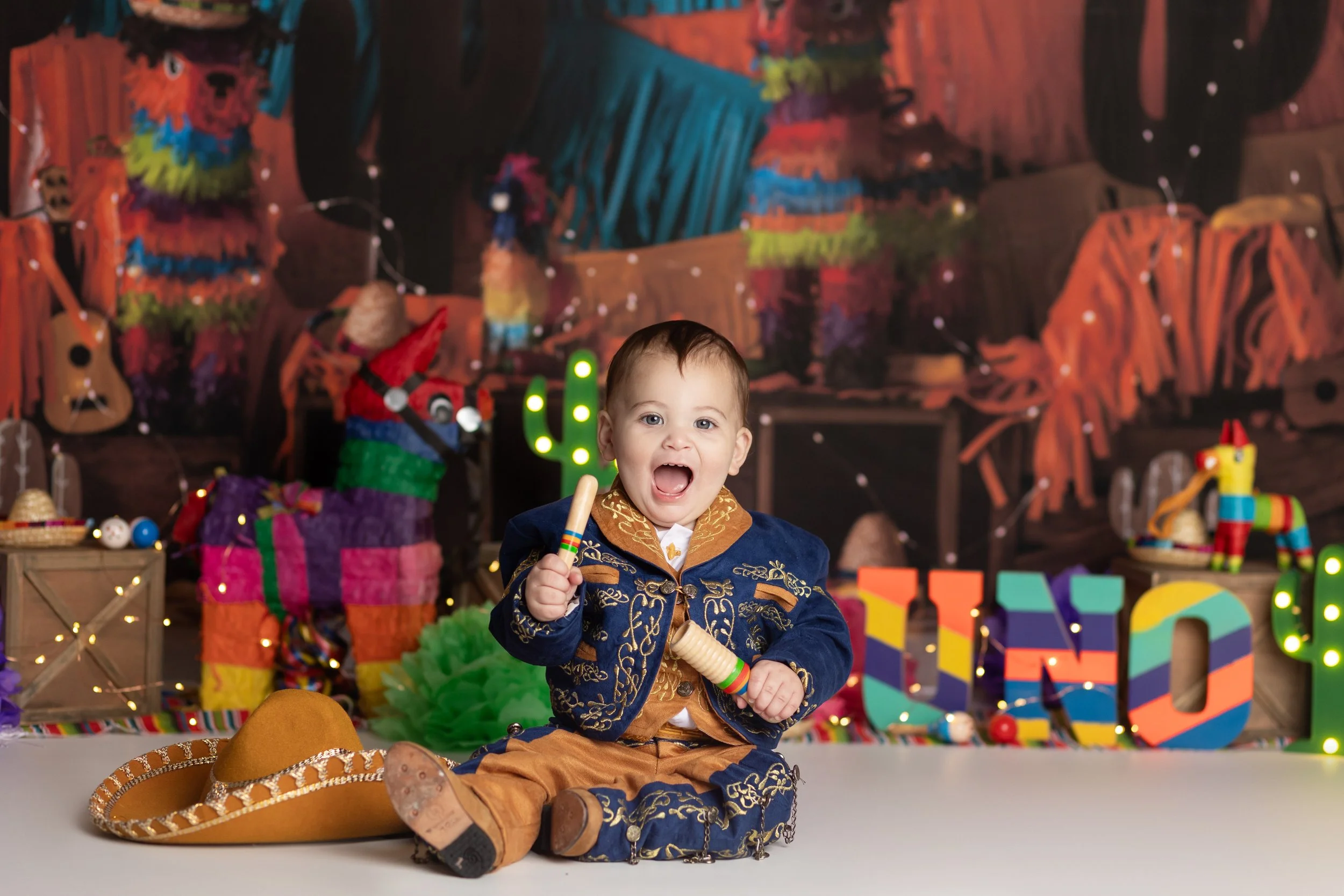 Fiesta cake smash theme – first birthday boy portrait with colorful setup