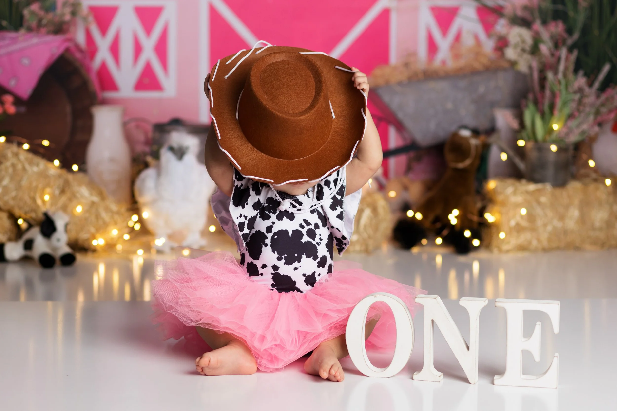Pink cowgirl cake smash theme – first birthday girl portrait with western setup
