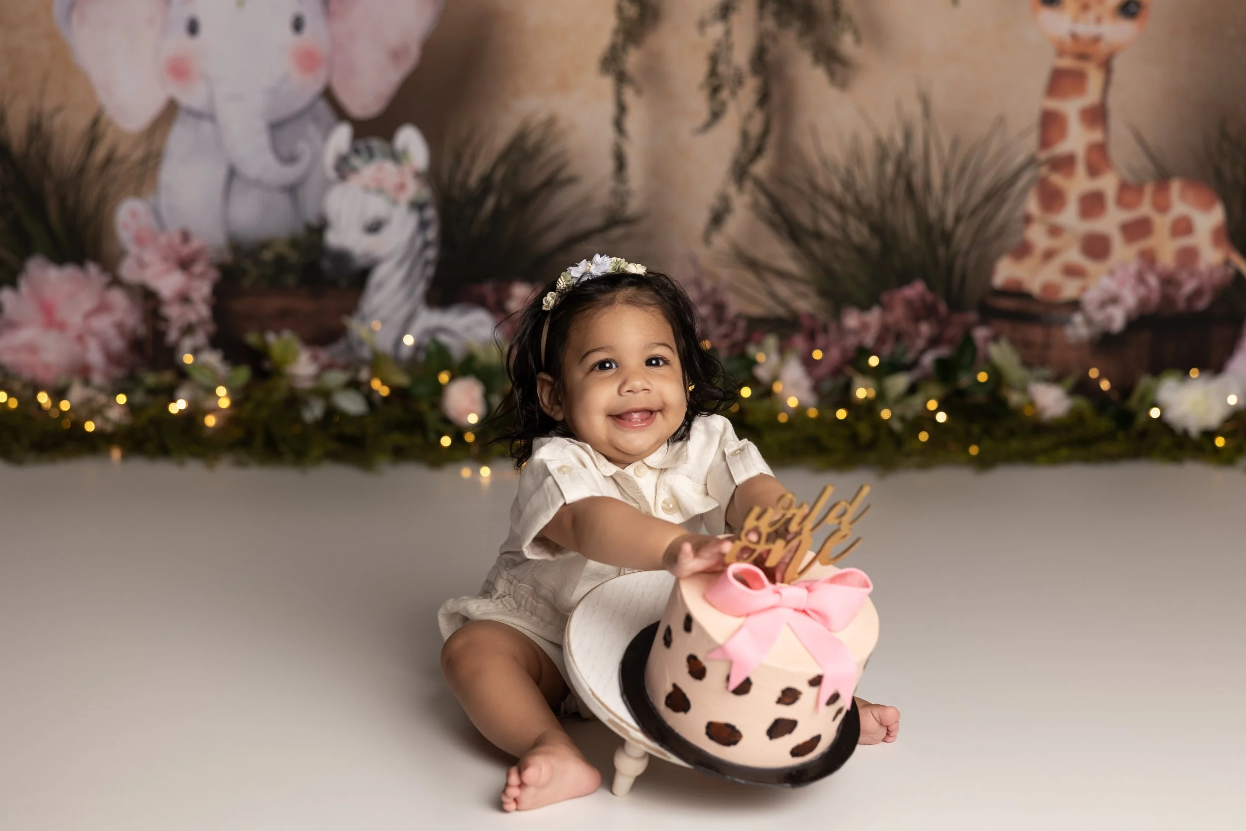 Girl safari cake smash – first birthday girl with animal print cake and pink decor