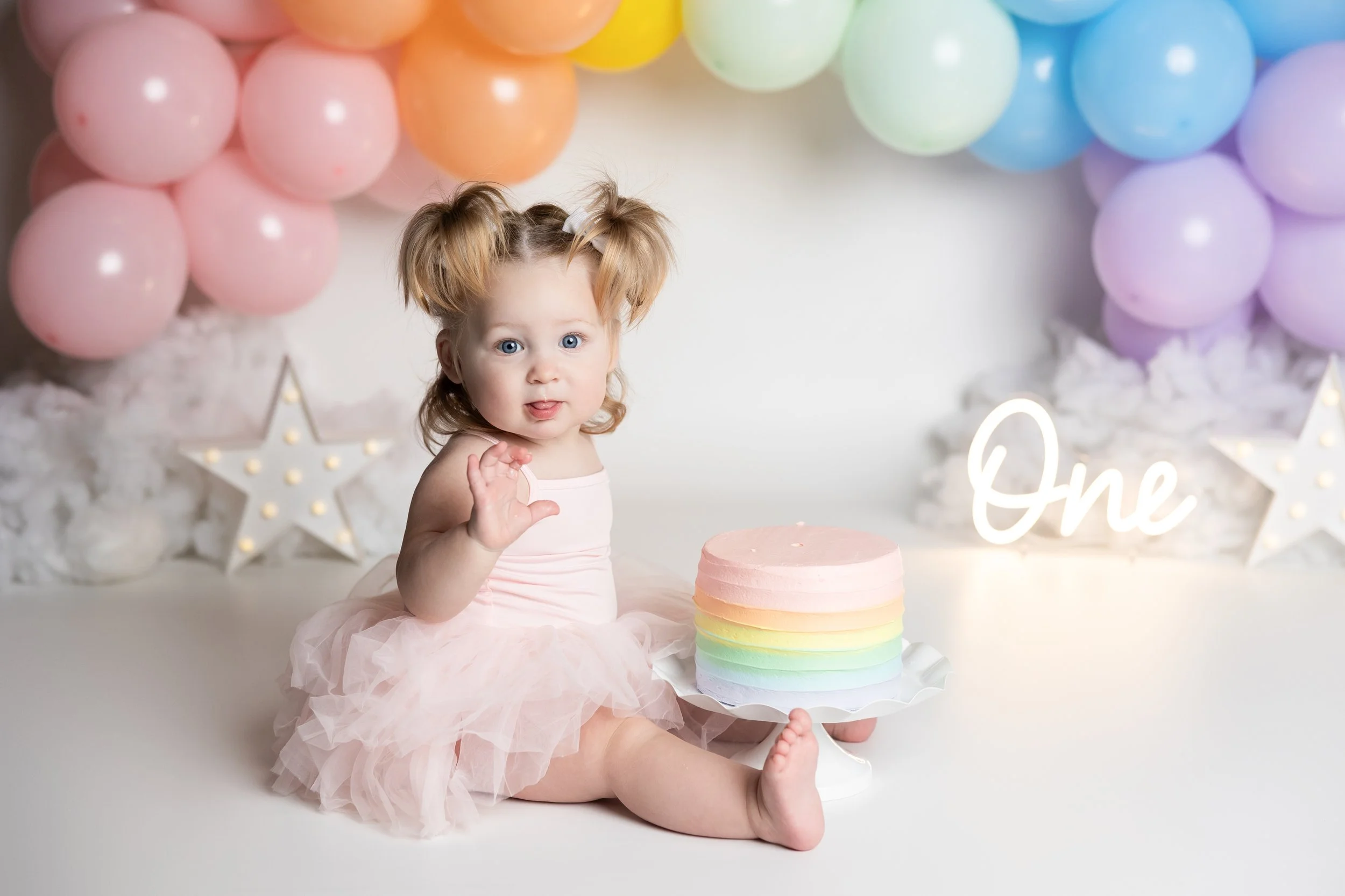 Rainbow cake smash – first birthday girl with pastel rainbow cake