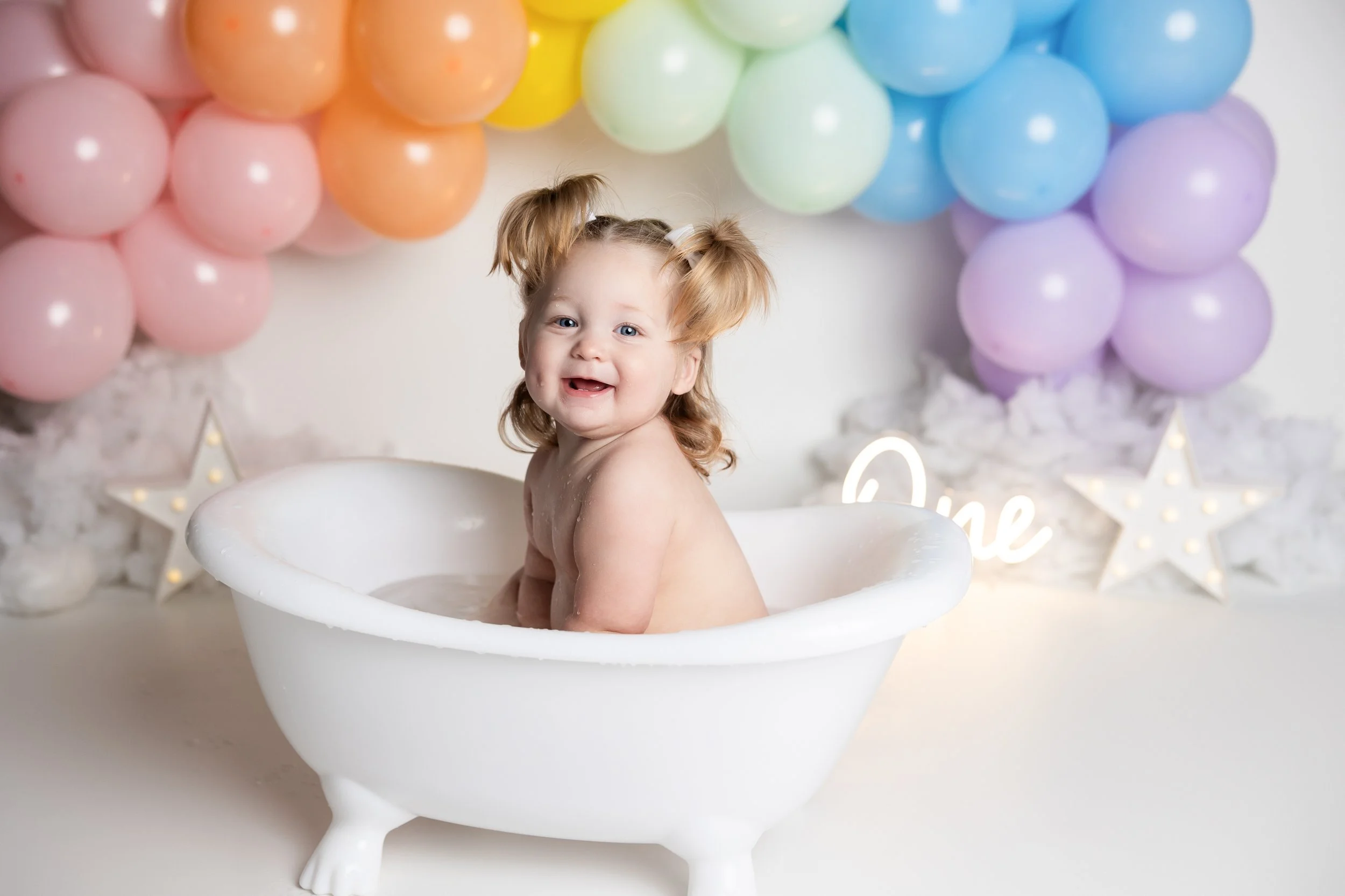 Cake smash bath photo – simple rainbow theme first birthday session