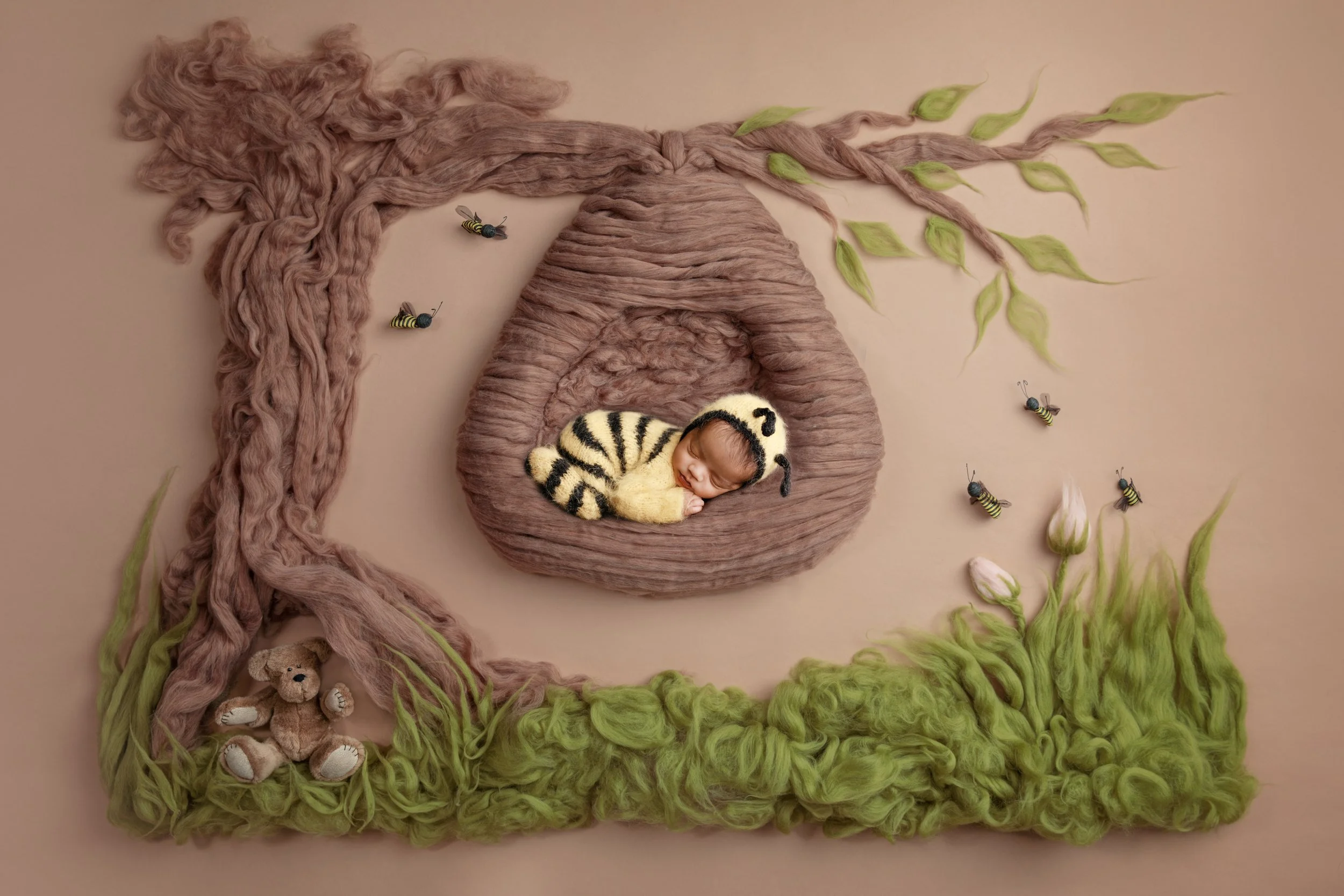 Baby in bee outfit posed in hive inspired setup