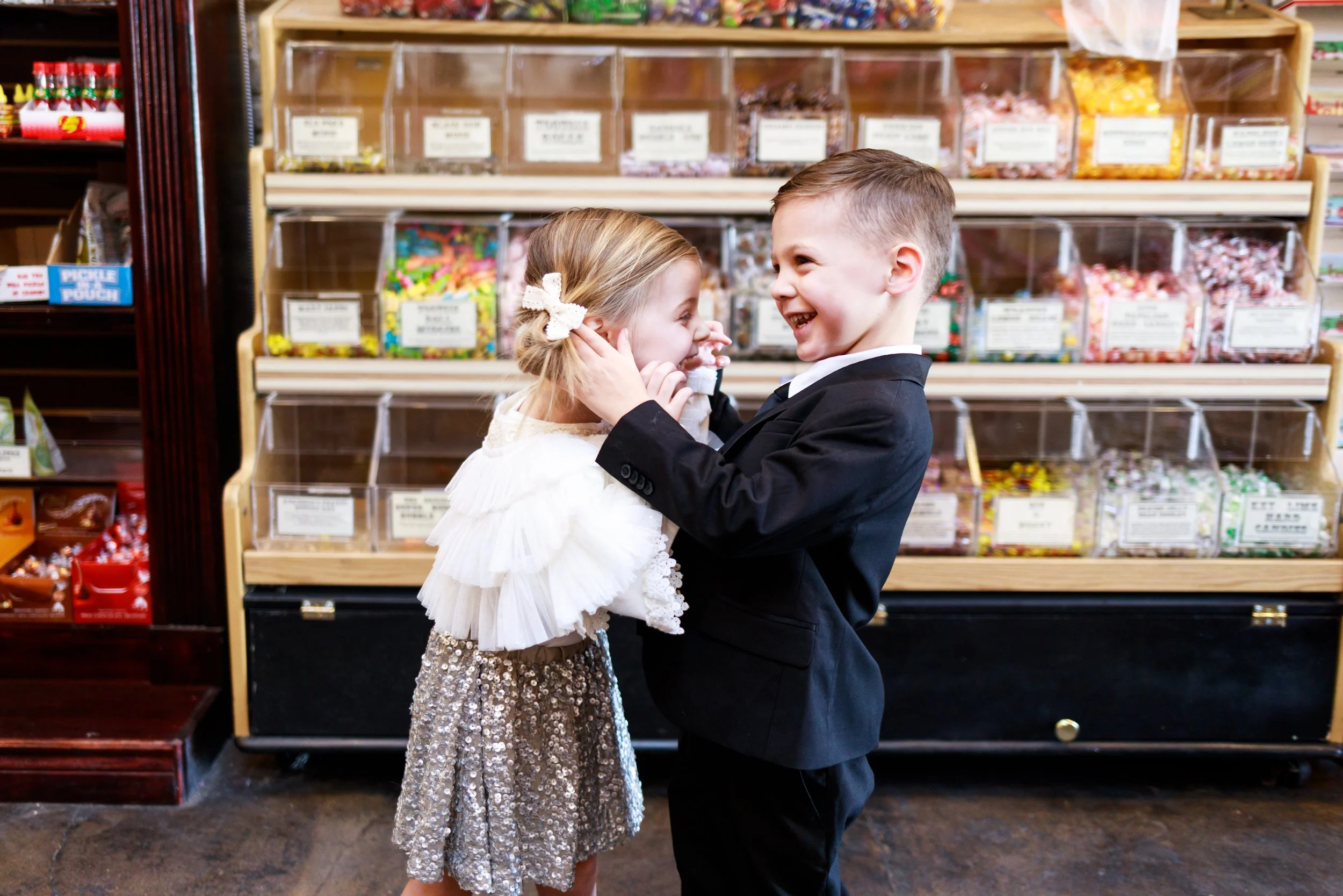 Twins laughing and fixing hair in candy shop