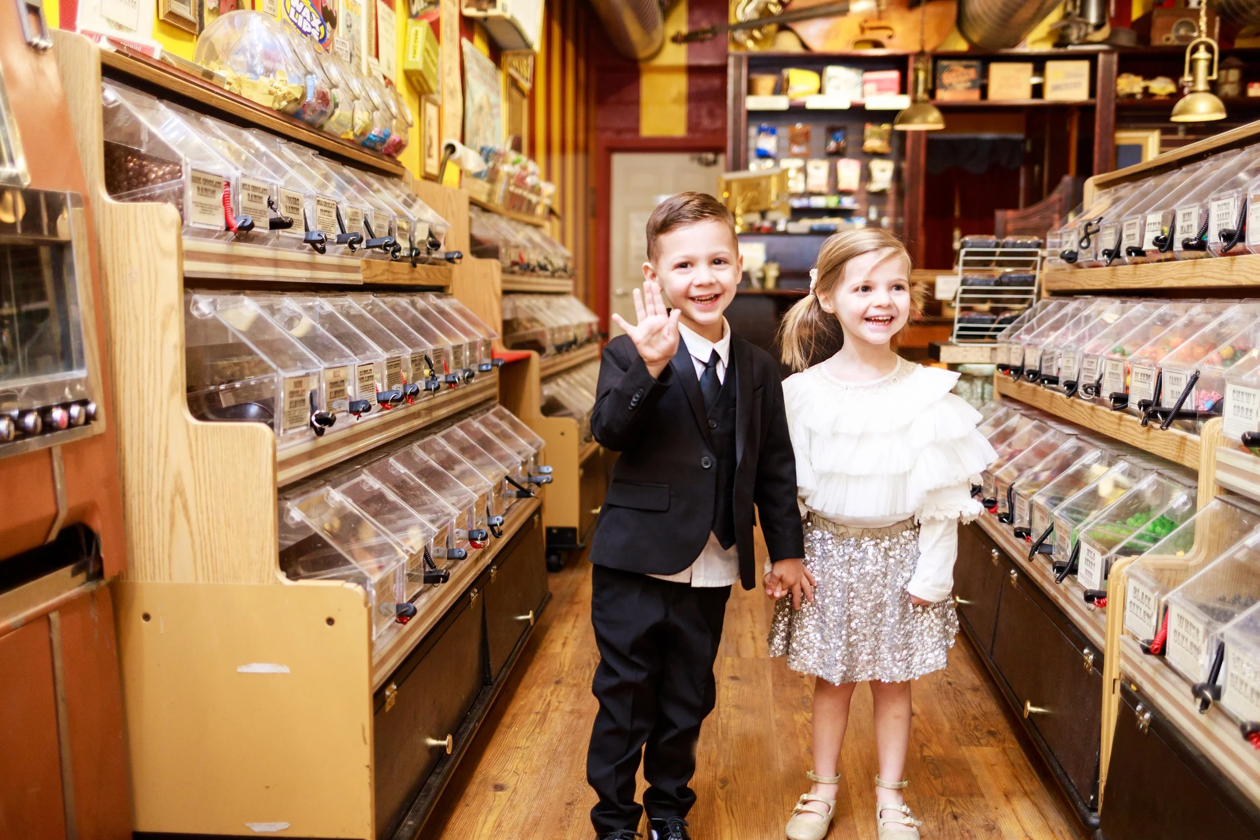 Twins walking through candy shop holding hands