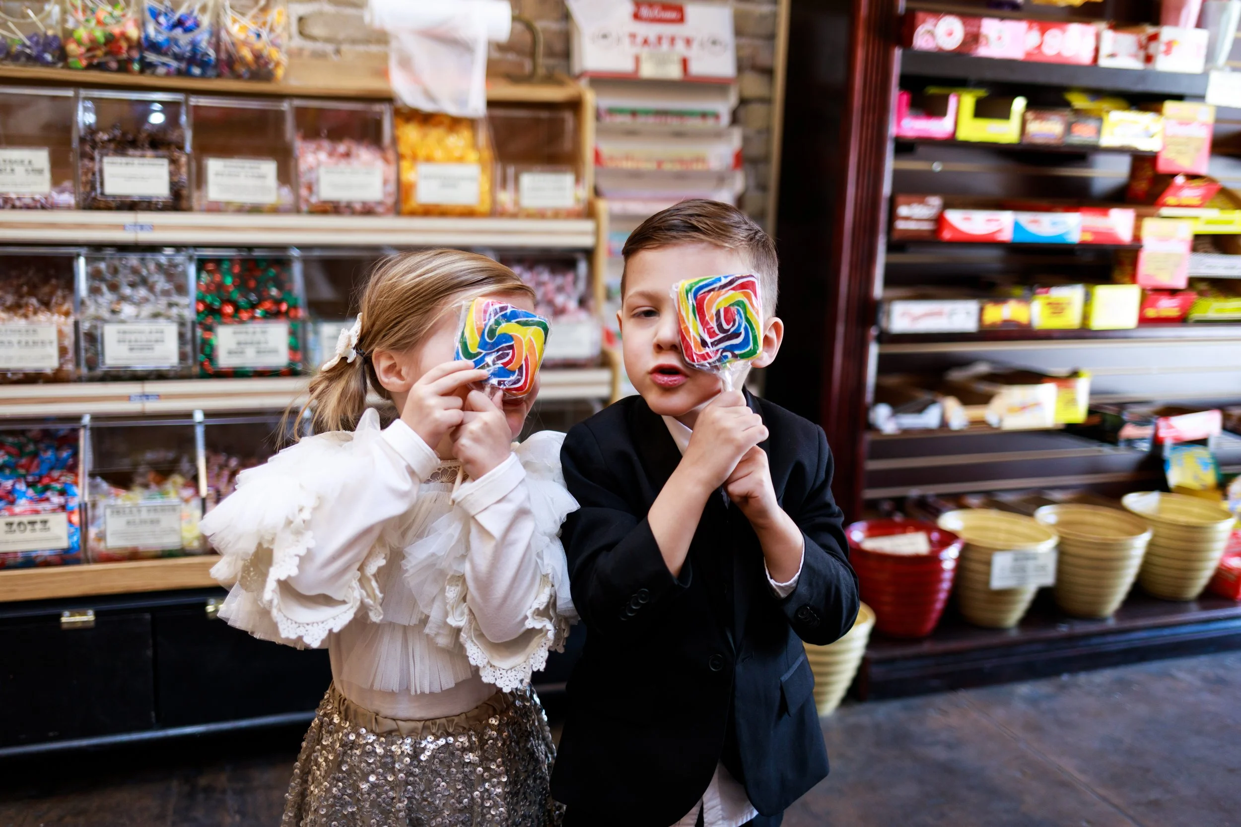 Twins holding rainbow lollipops