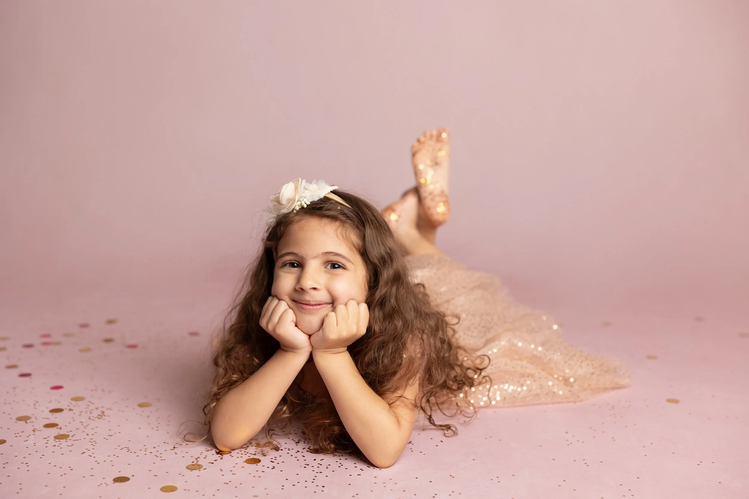 Smiling Girl Lying in Glitter and Confetti