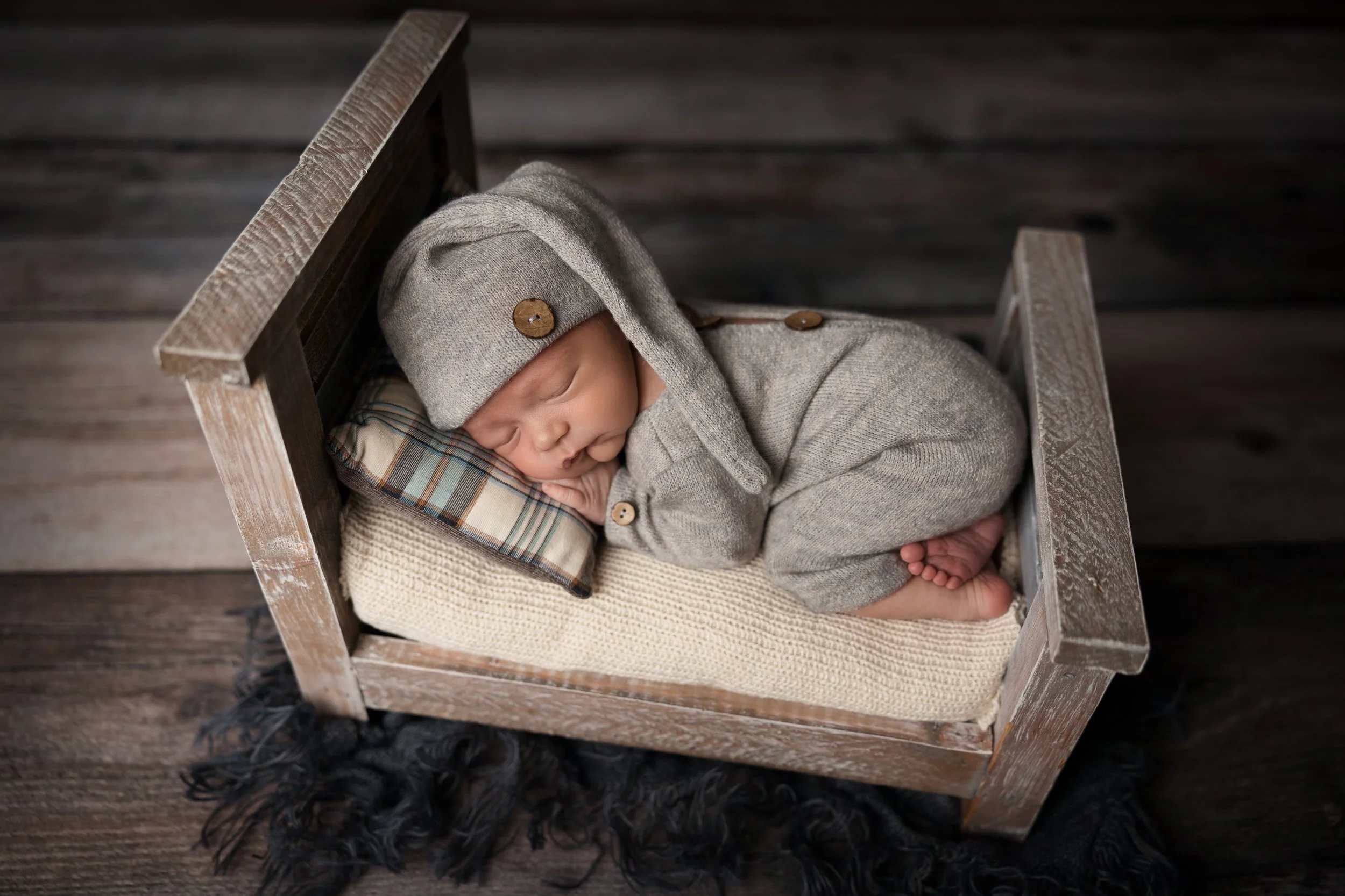 Sleepy Newborn in Rustic Bed Prop