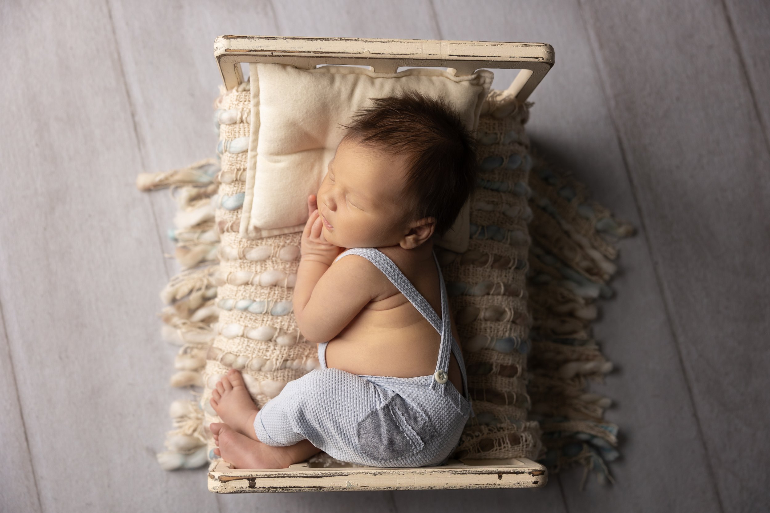 Overhead Newborn Portrait in Blue Suspenders