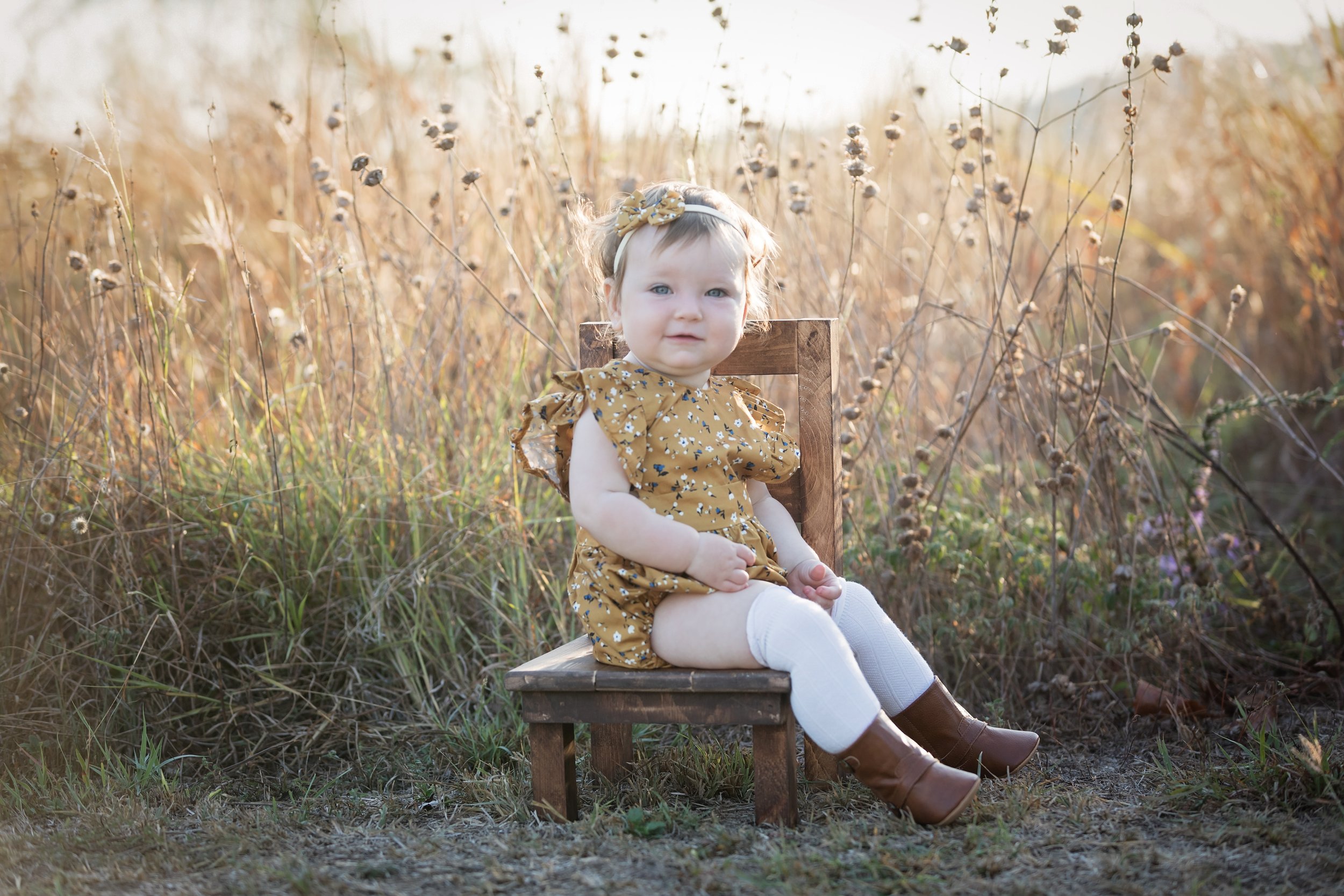 one-year-old-girl-sitting-on-vintage-chair-outdoors-austin.jpg