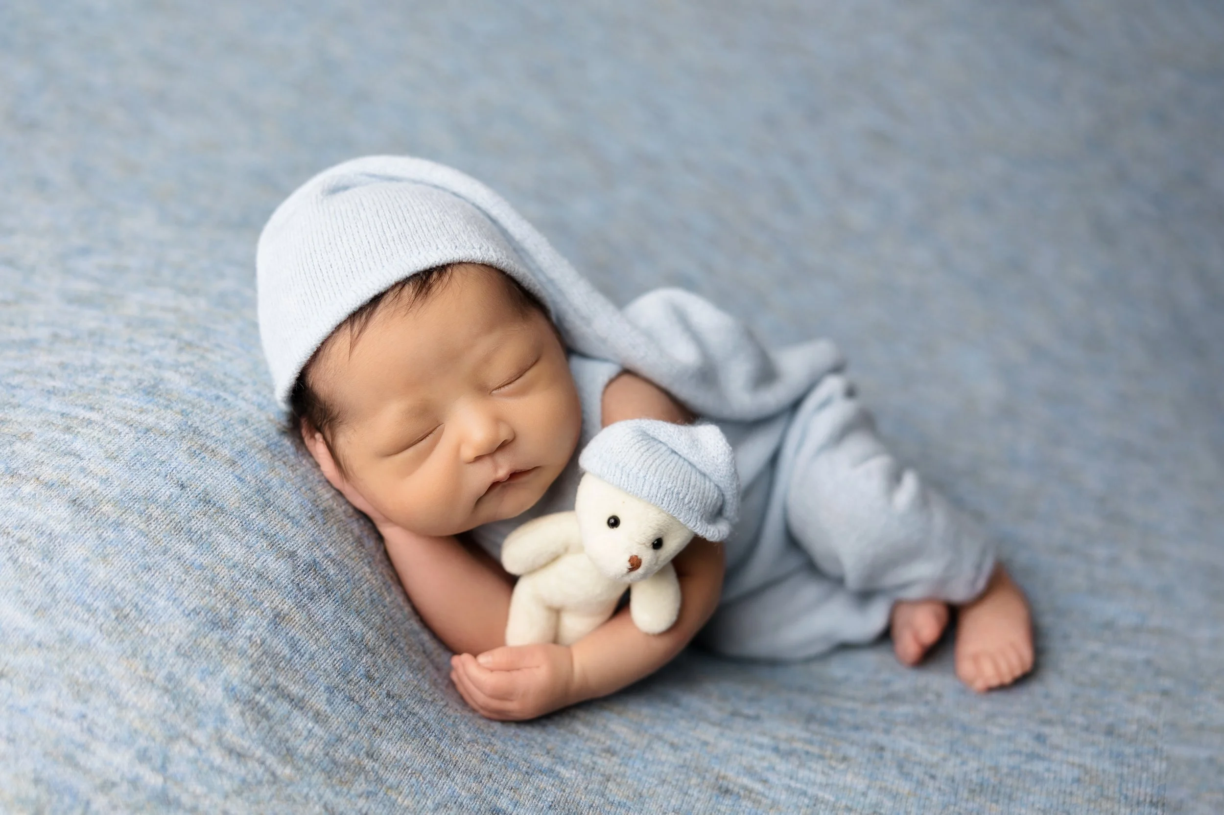 Sleeping newborn baby posed during a studio newborn photography session at 2 to 3 weeks old in Austin, Texas.