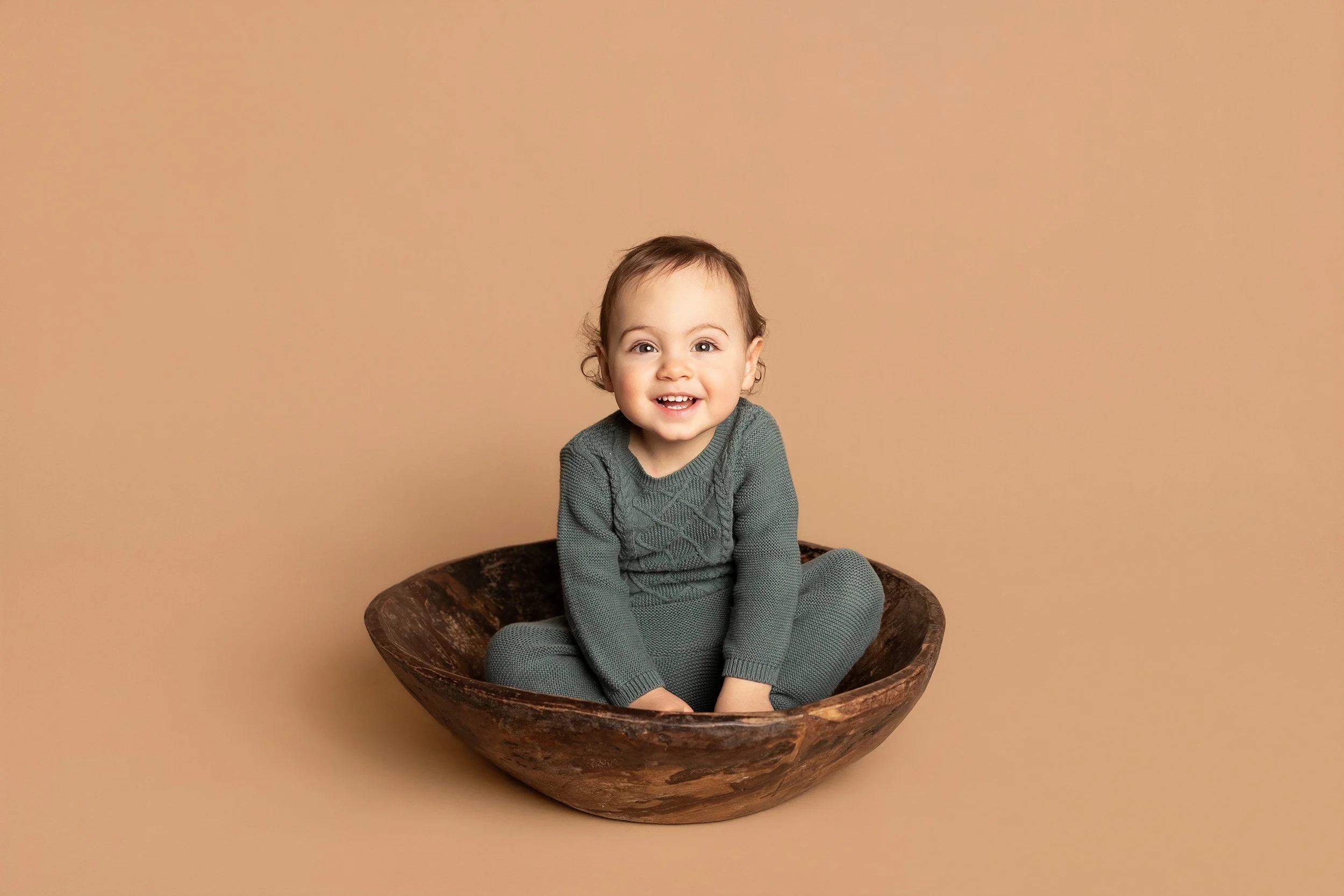 toddler boy sitting in wooden bowl in Austin Texas studio