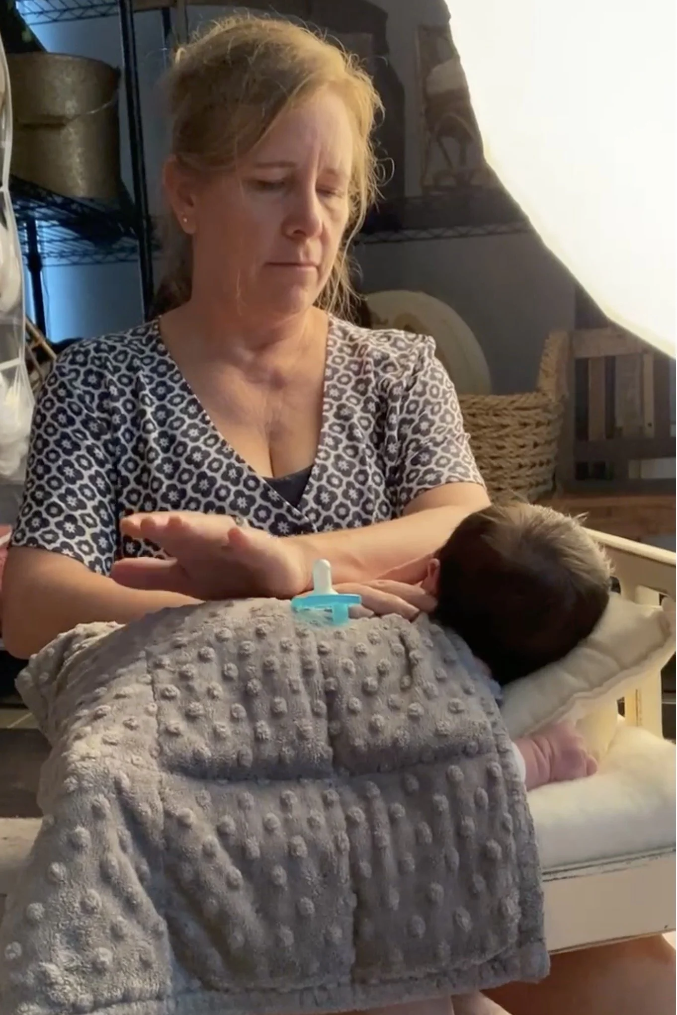 Newborn baby resting with small weighted blanket during posed newborn photography session for comfort and soothing