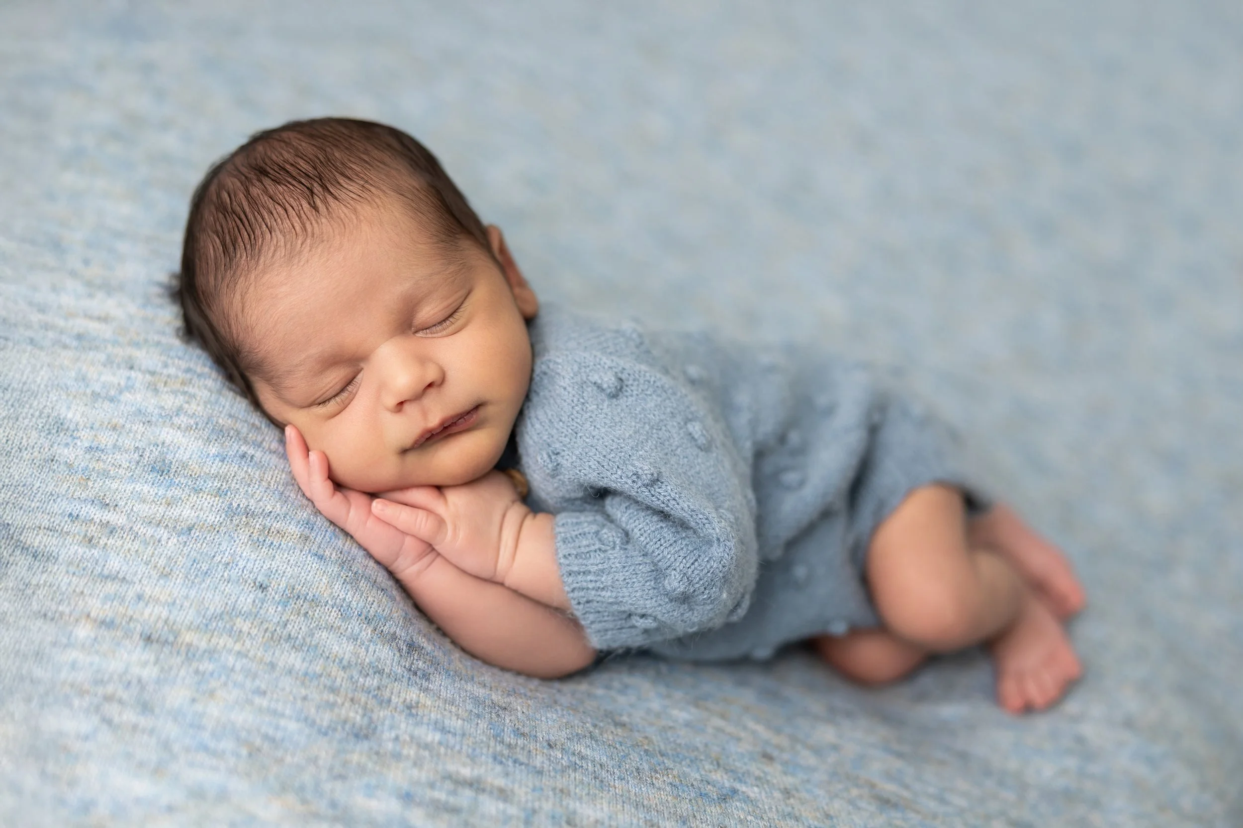 Peacefully sleeping newborn baby photographed in a professional Austin newborn photography studio.
