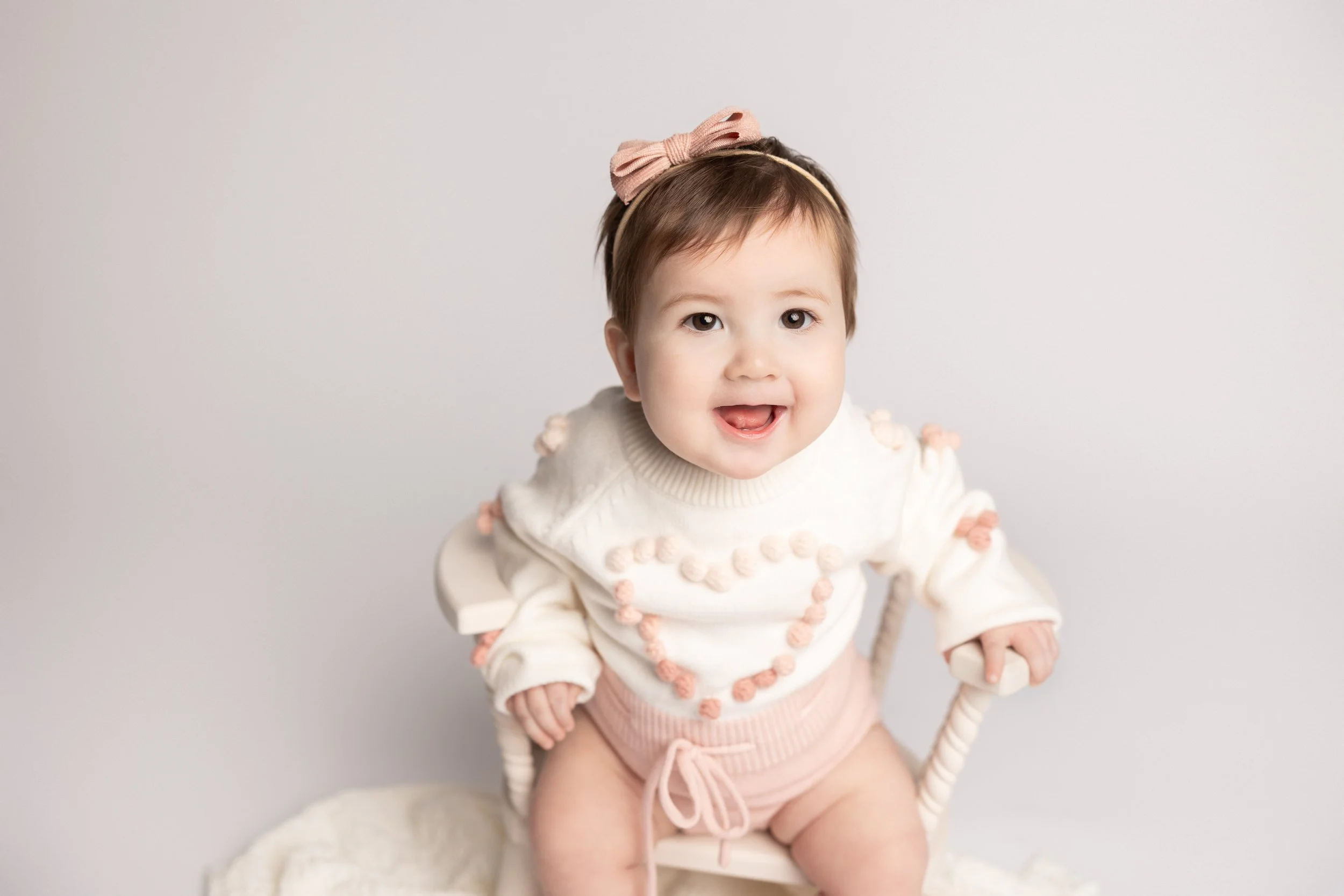 Baby girl smiling during her sitter milestone session at an Austin photography studio