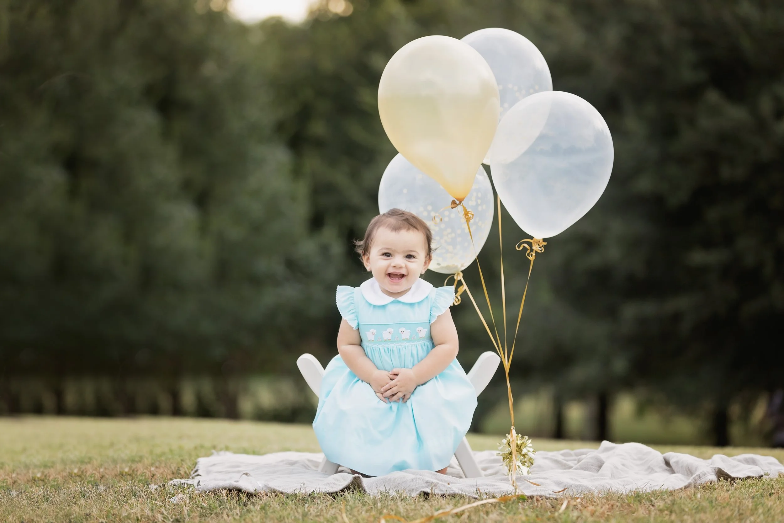 First birthday photos in Austin Texas at Butler Park with baby girl and balloons by Austin baby photographer