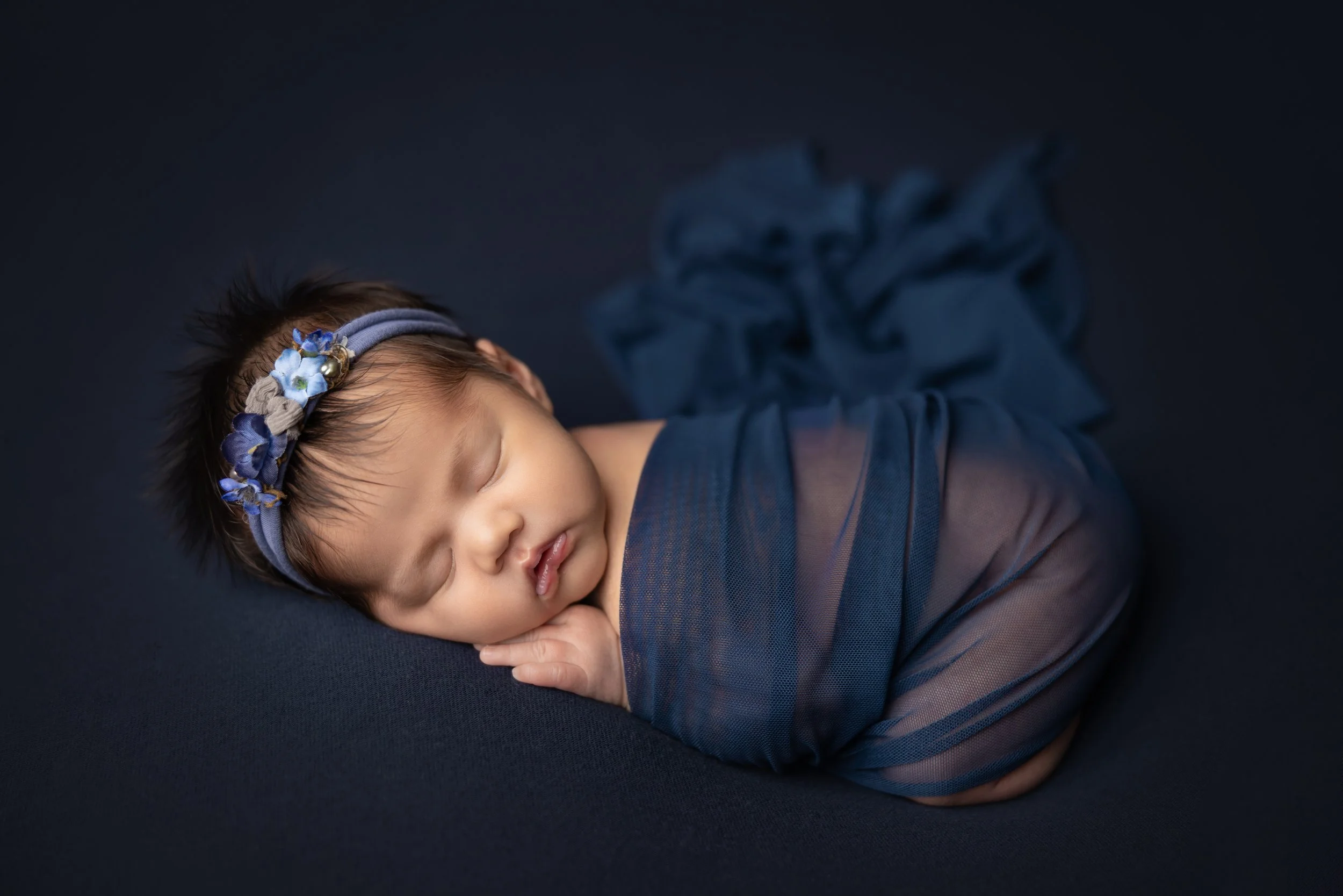 newborn girl wrapped in blue posed bum up in austin texas studio