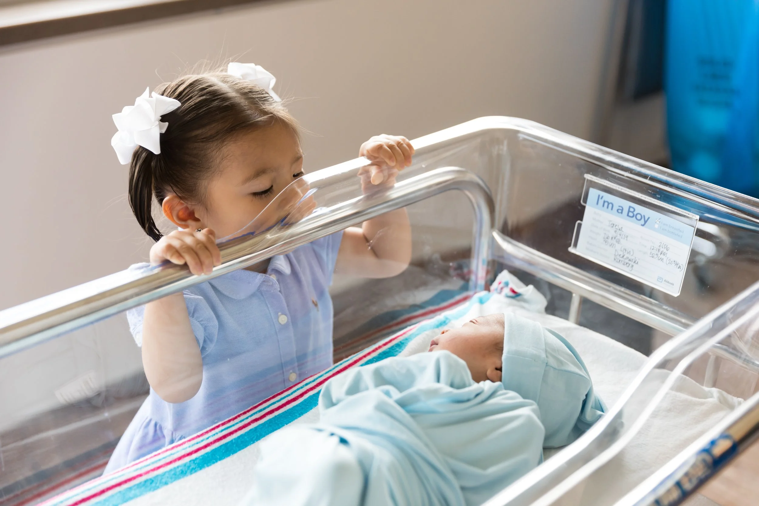 Older sibling meeting a newborn baby in the hospital during a Fresh 48 photography session in Austin.