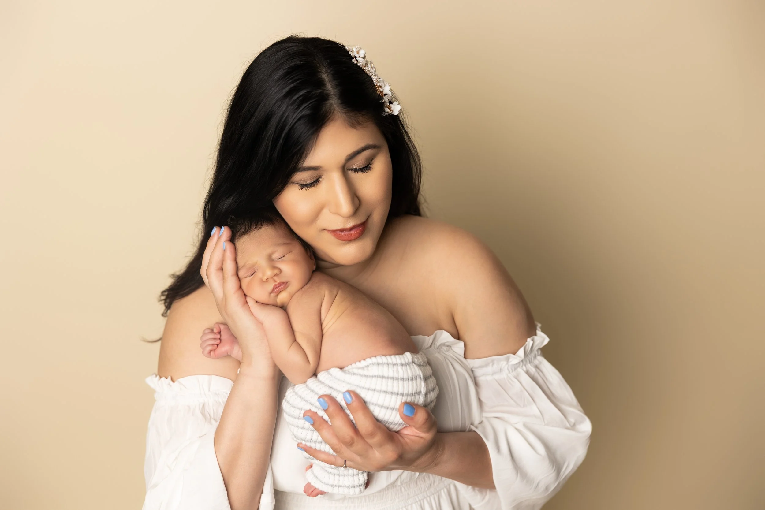 Mother holding her sleeping newborn during a studio newborn photography session in Austin, Texas.