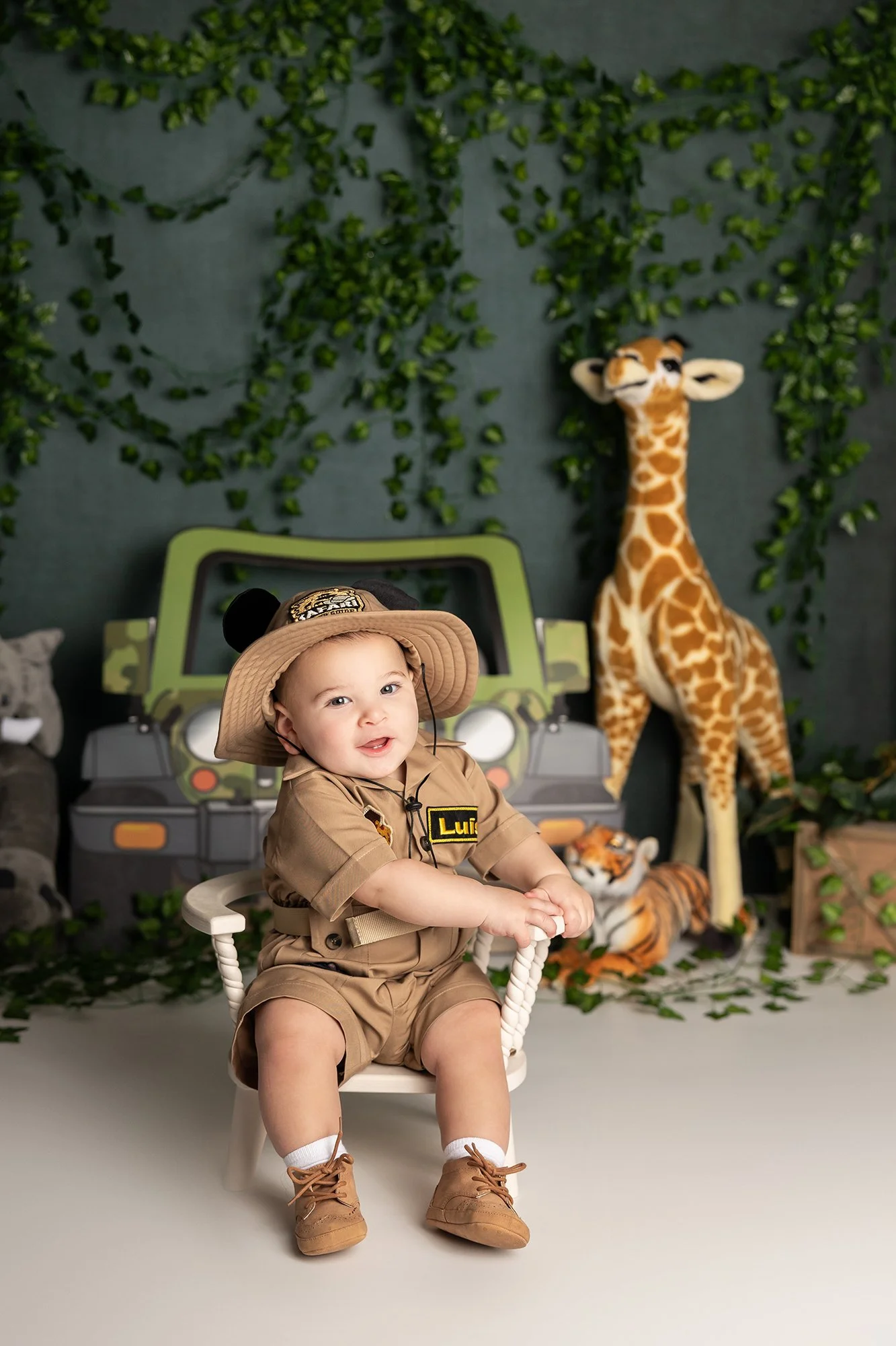 Safari themed first birthday cake smash session in Austin TX with baby in neutral jungle setup