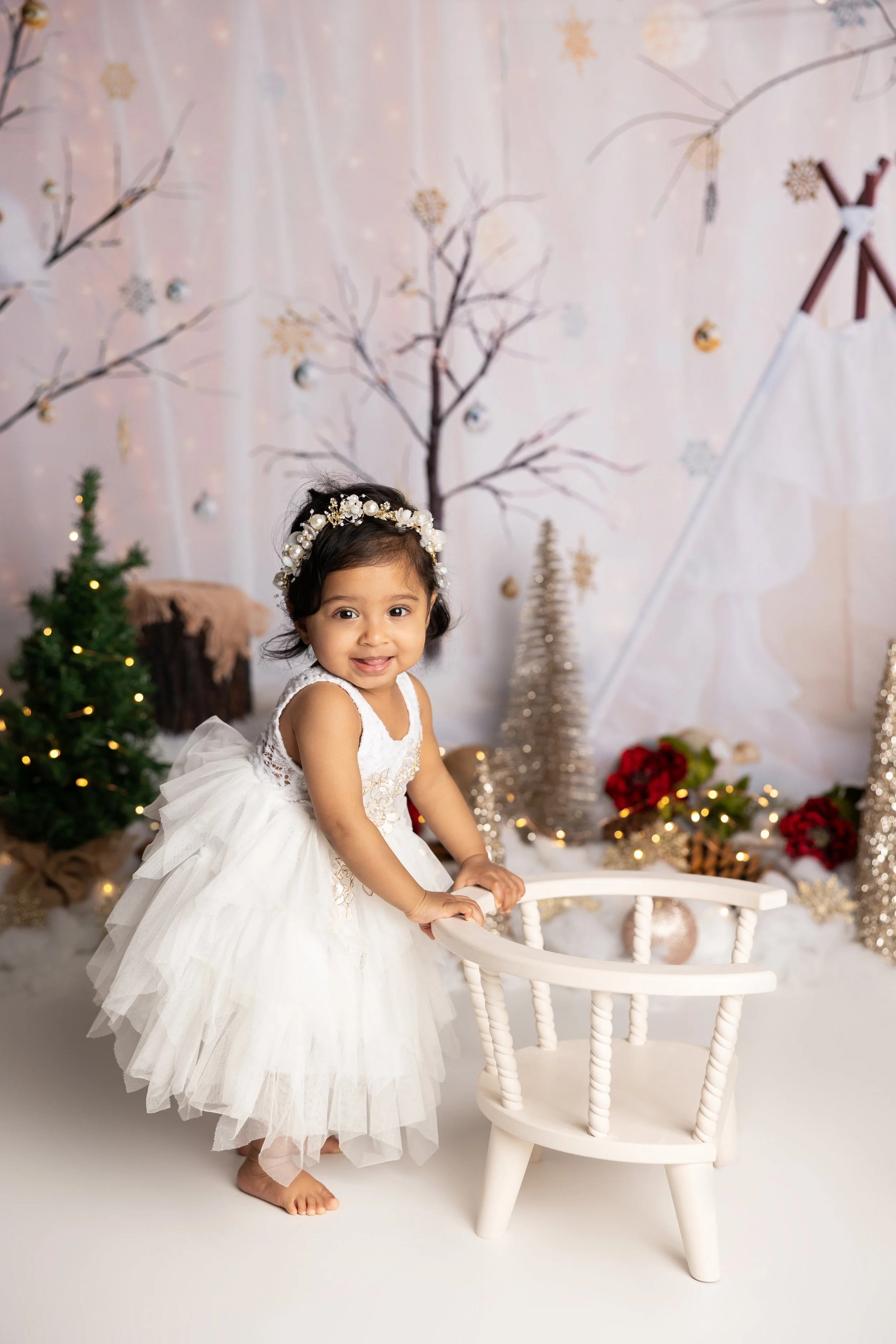Winter-themed first birthday portrait session with classic holiday-inspired styling.