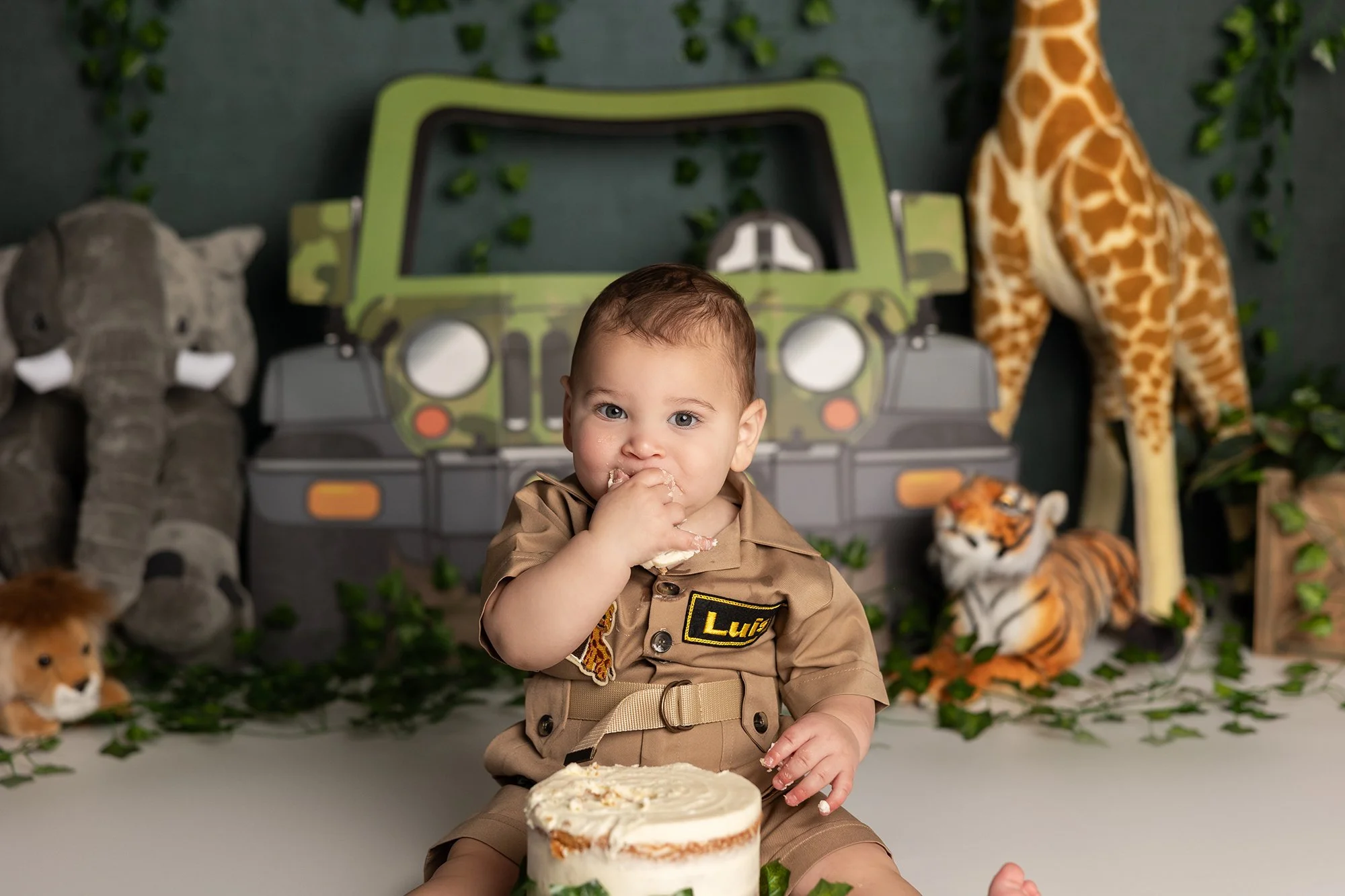 Baby boy enjoying cake during first birthday cake smash session in Austin TX