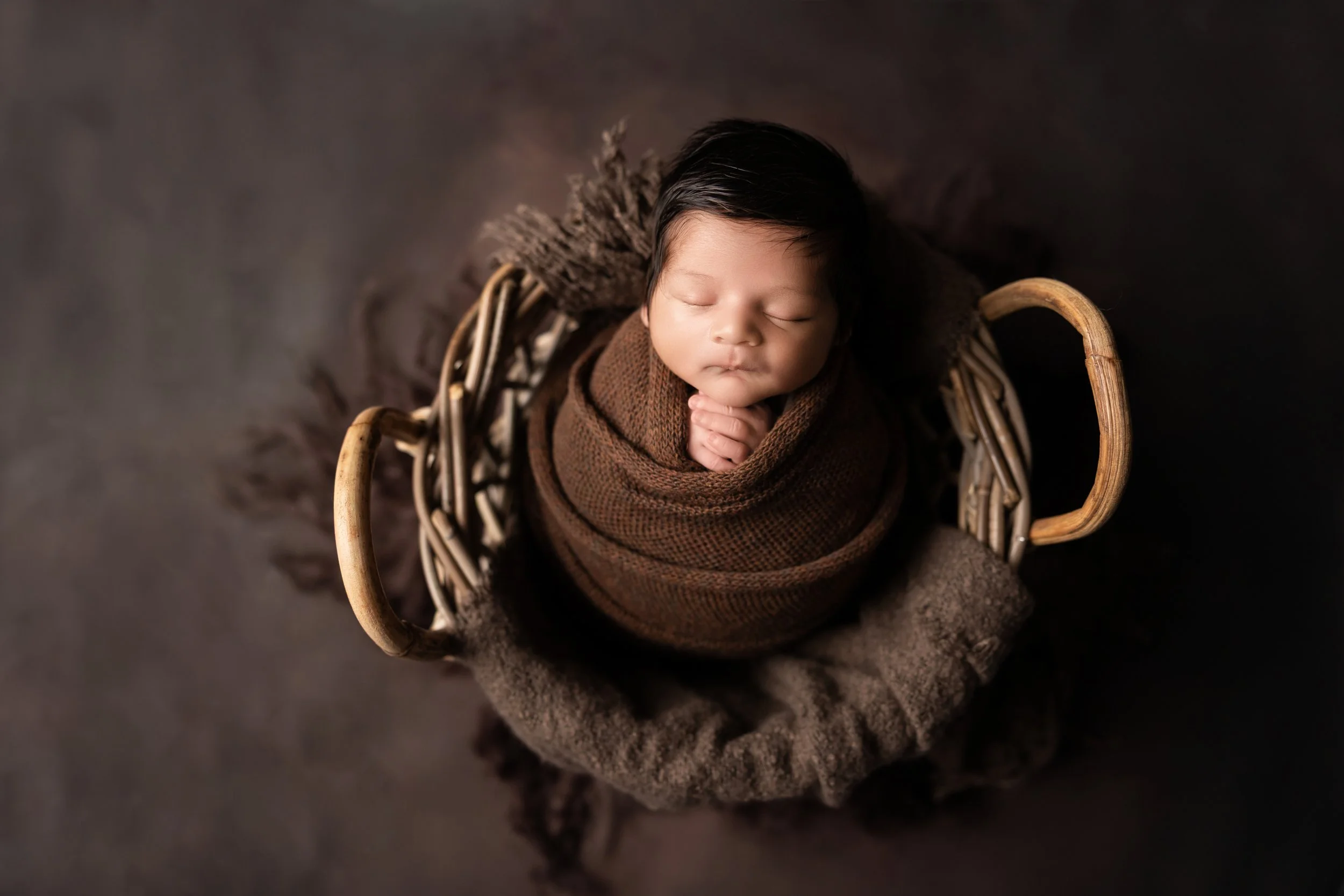 newborn baby boy wrapped in brown with monochromatic matching set in Austin TX photography studio