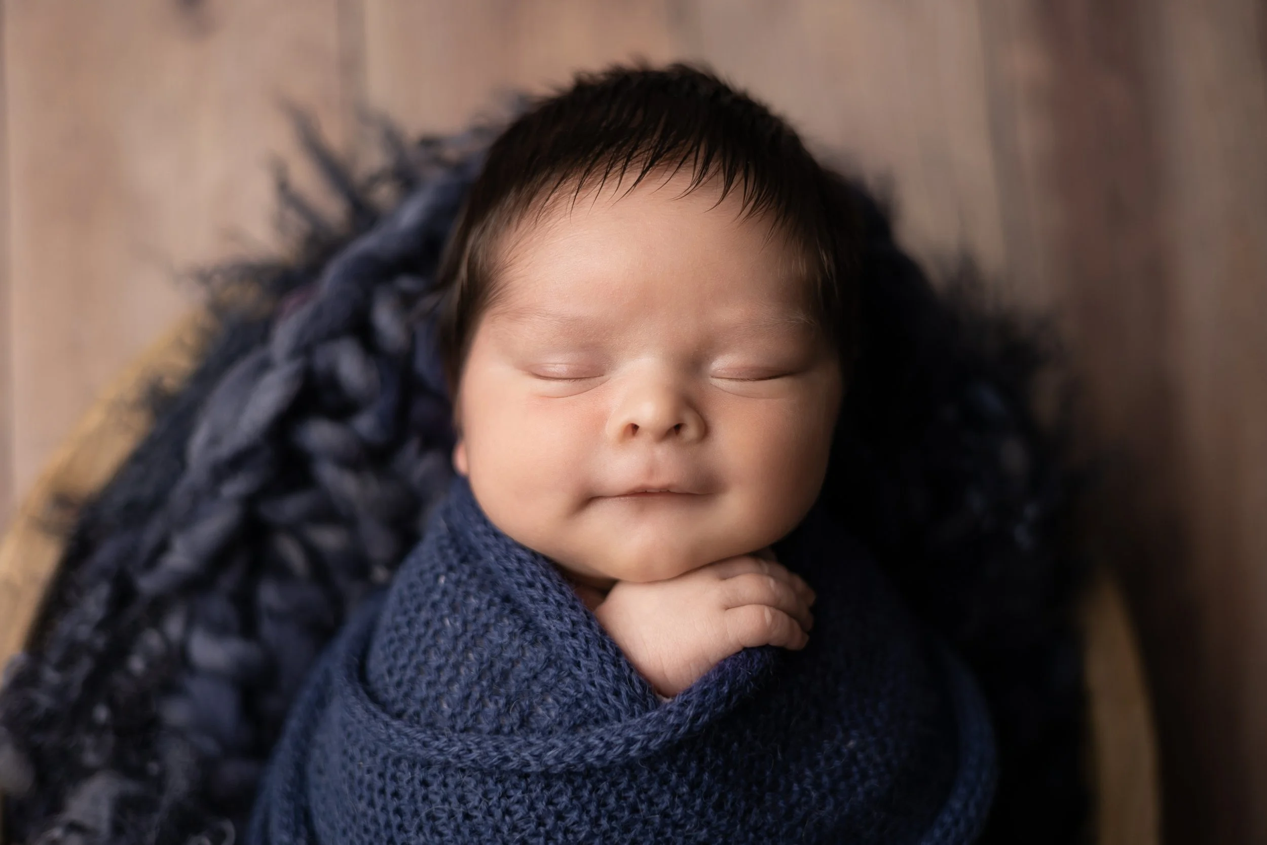 Newborn baby boy wrapped in soft neutral tones during an Austin studio newborn photography session