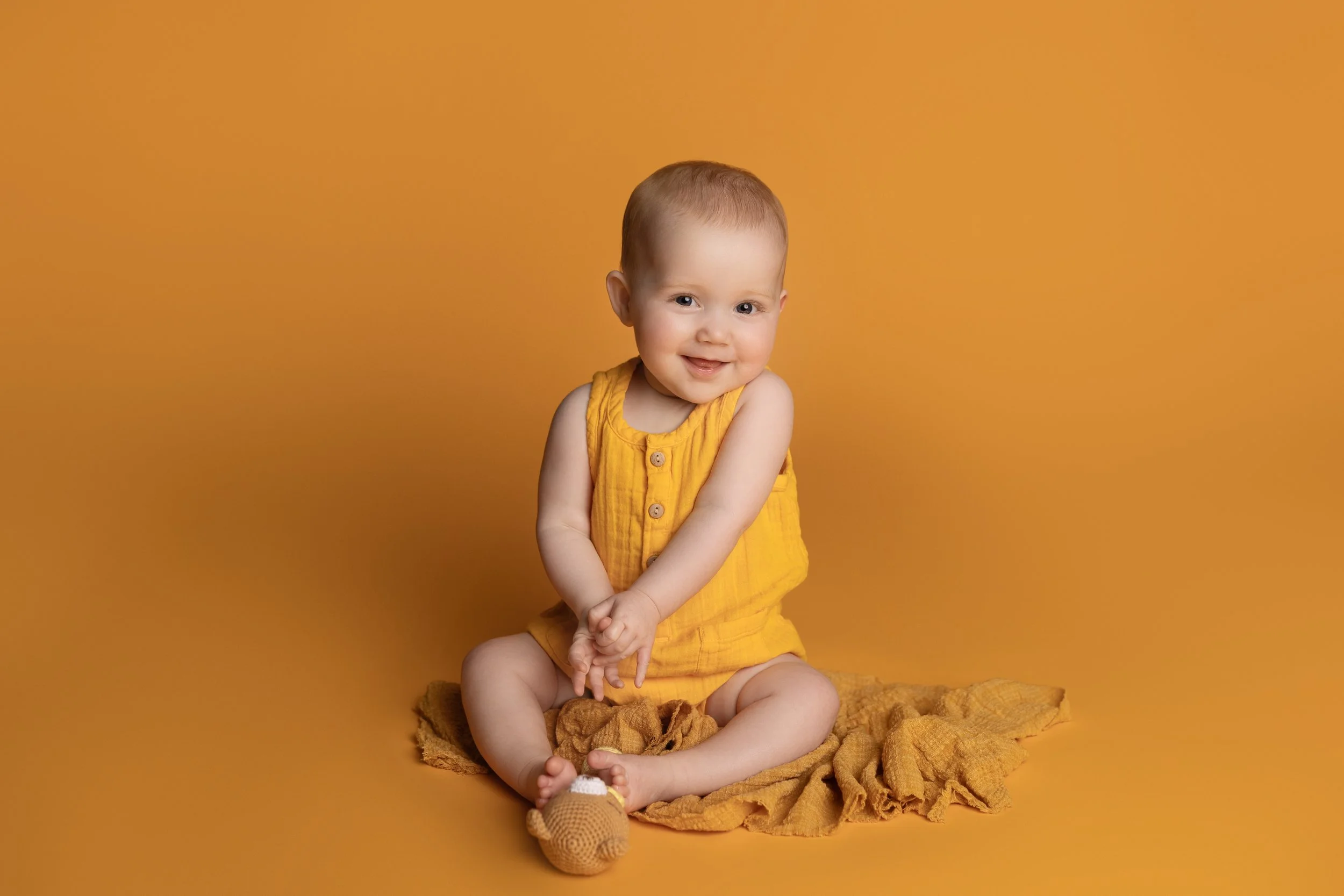 baby sitting in yellow monochromatic photography setup with matching tones