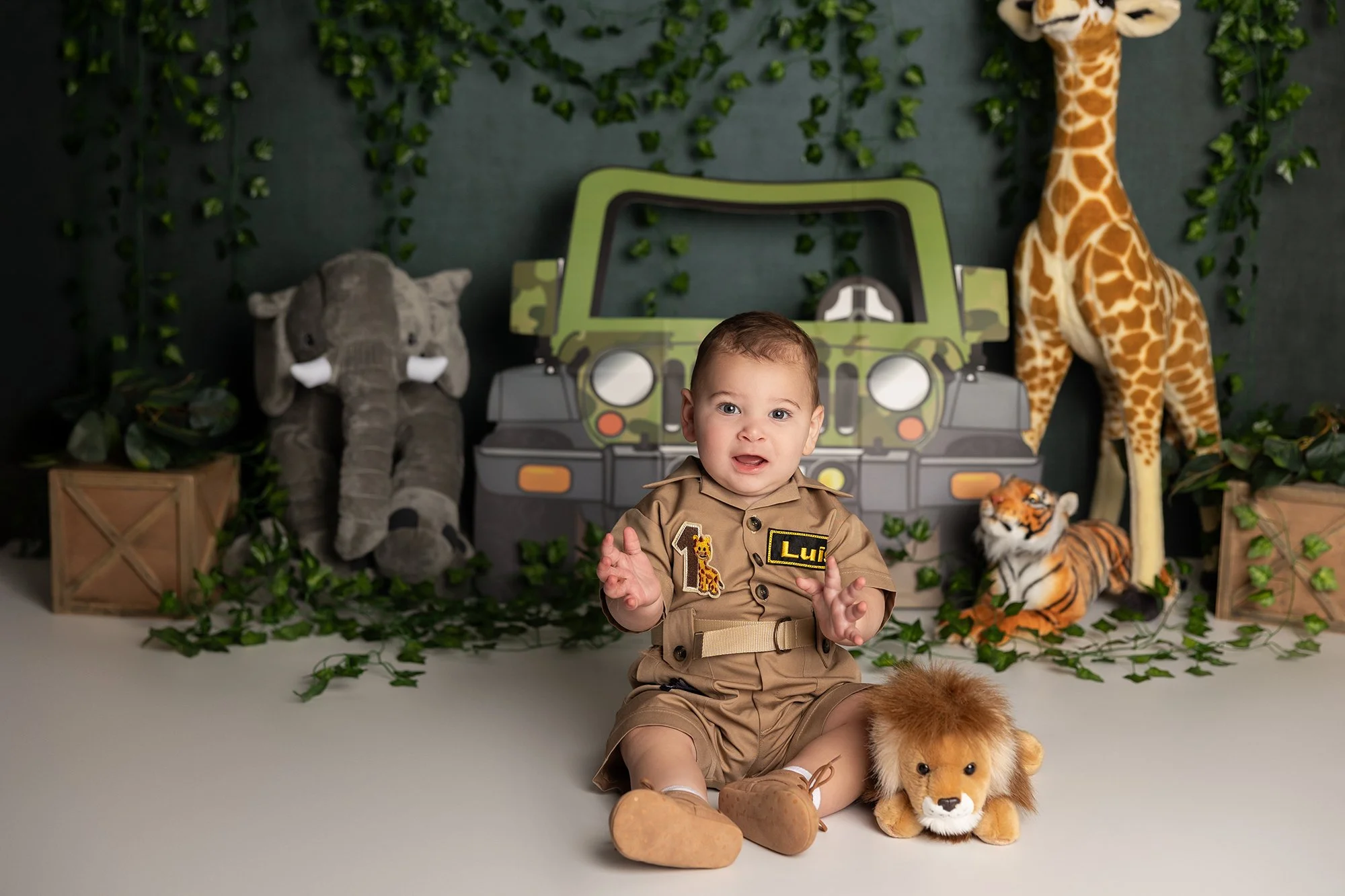 Baby boy playing with toy lion during safari themed cake smash session in Austin TX