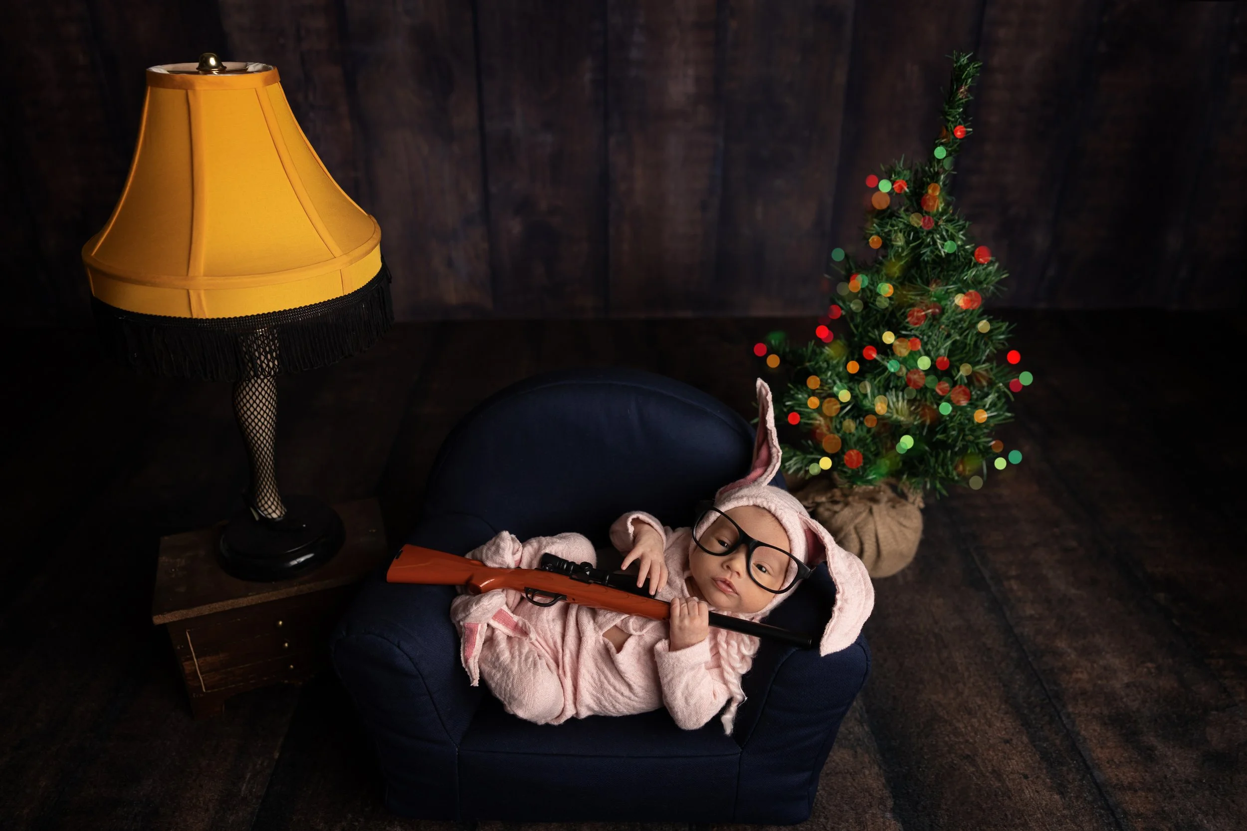 Christmas Story-inspired newborn portrait featuring holiday movie references and playful seasonal details.