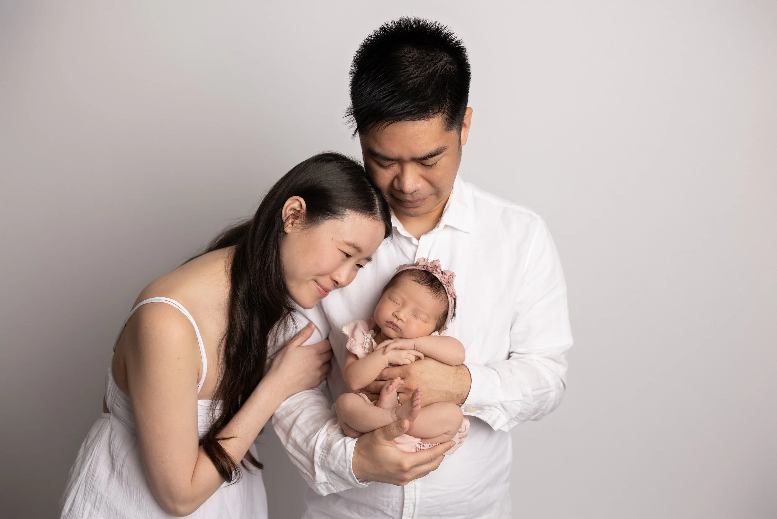 Parents holding their newborn baby during a newborn photography session in Austin, Texas.