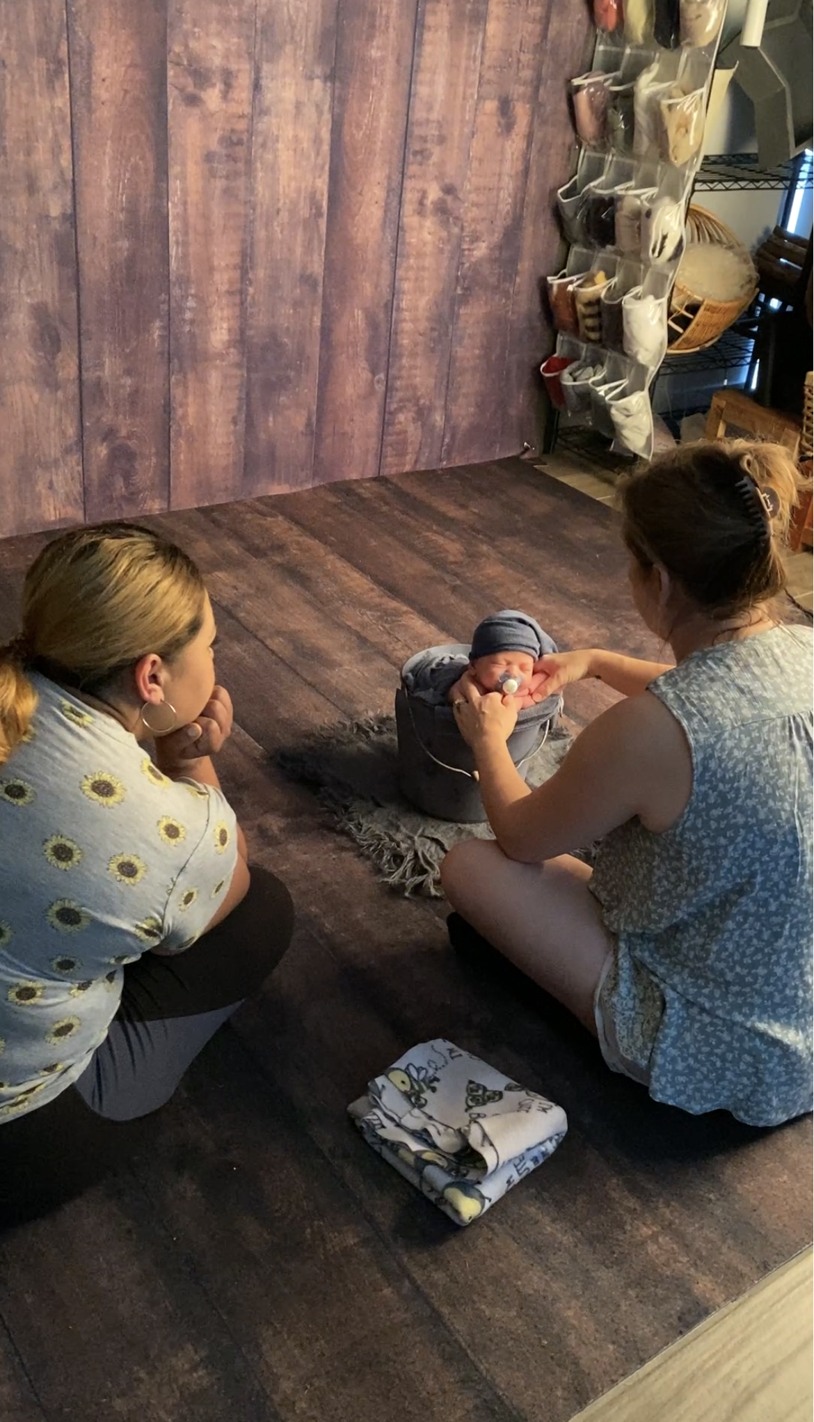 Photographer receiving one-on-one newborn photography training while learning newborn posing and workflow techniques in an Austin studio.