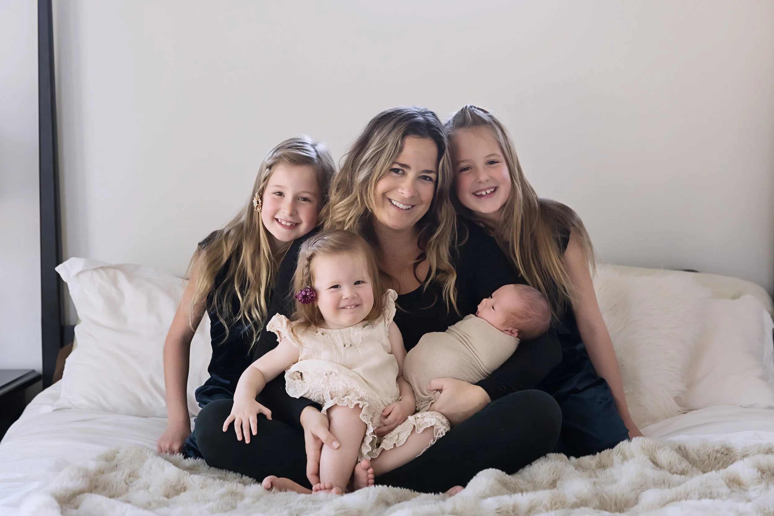 Mother with her newborn and older children during an in-home lifestyle newborn photography session in Austin.