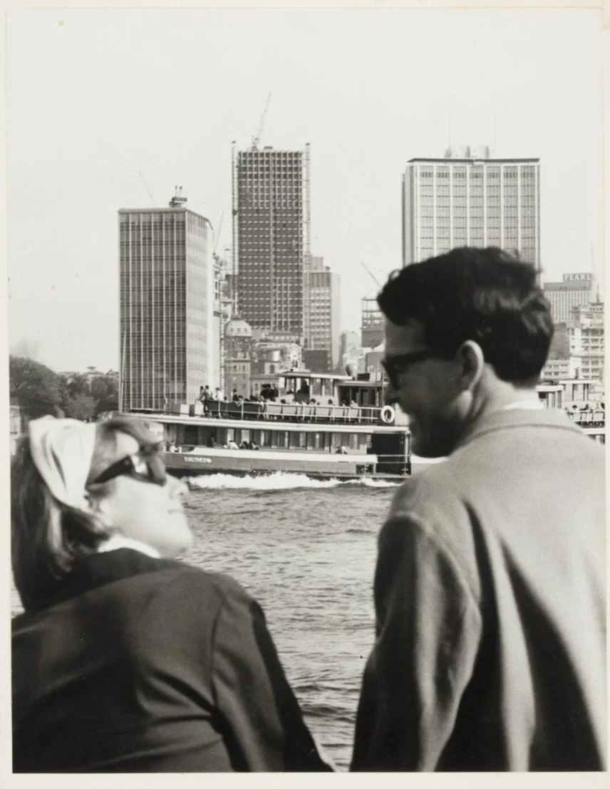 Couple on ferry as Karingal goes past in the background and State Office Block nears completion], Oct 1965