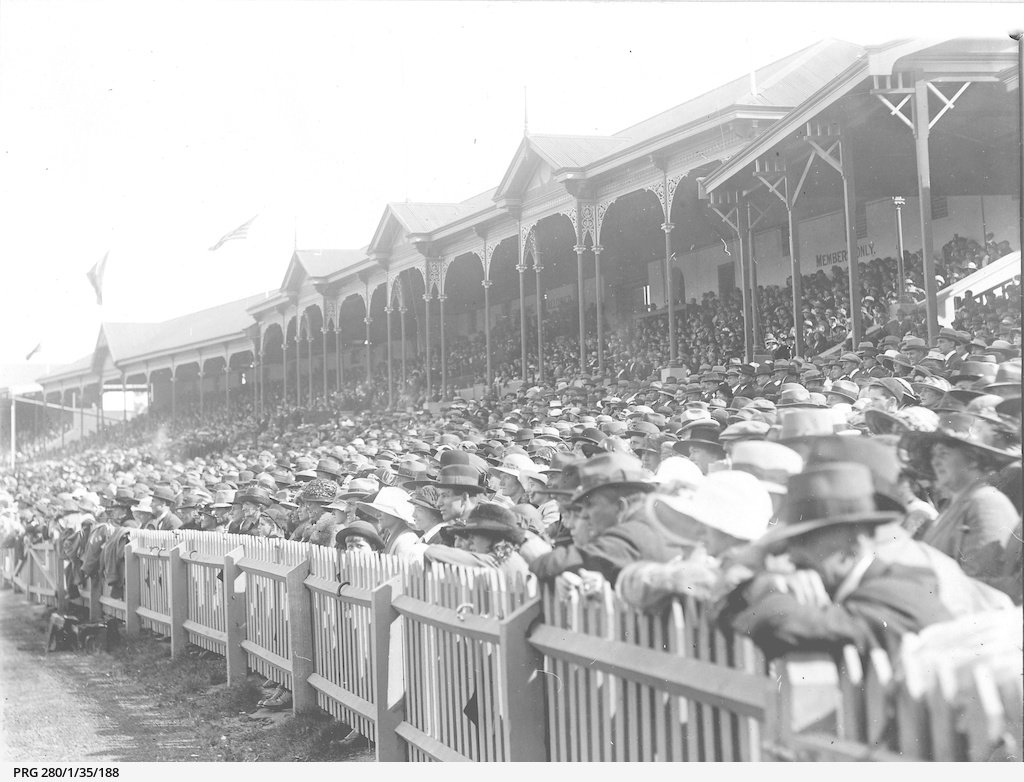 Close view of a section of a crowd of spectators attending a sporting function at the Adelaide Oval; the grandstand can be seen in the background c1923