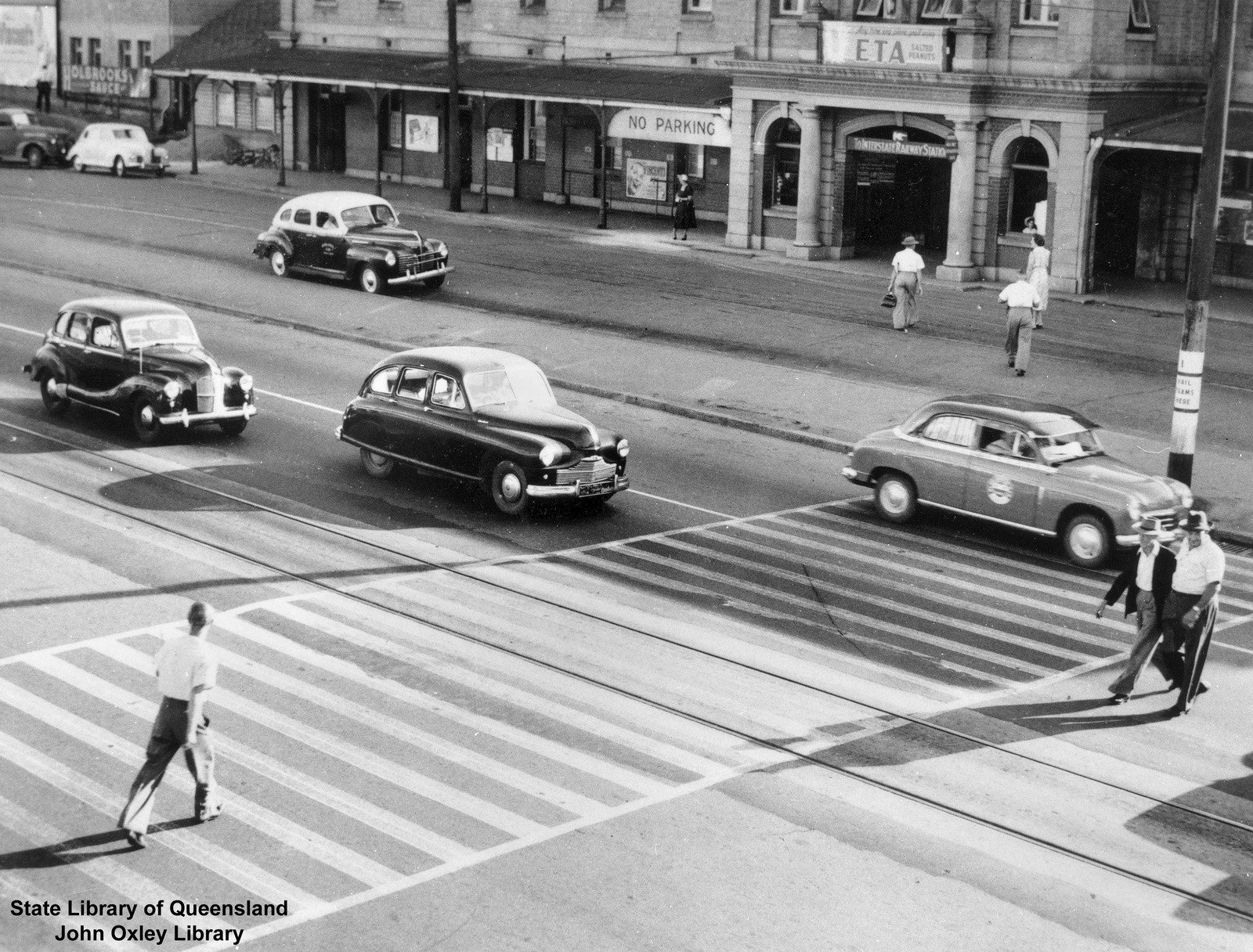 Pedestrians crossing the road in front of South Brisbane Railway Station, 1954