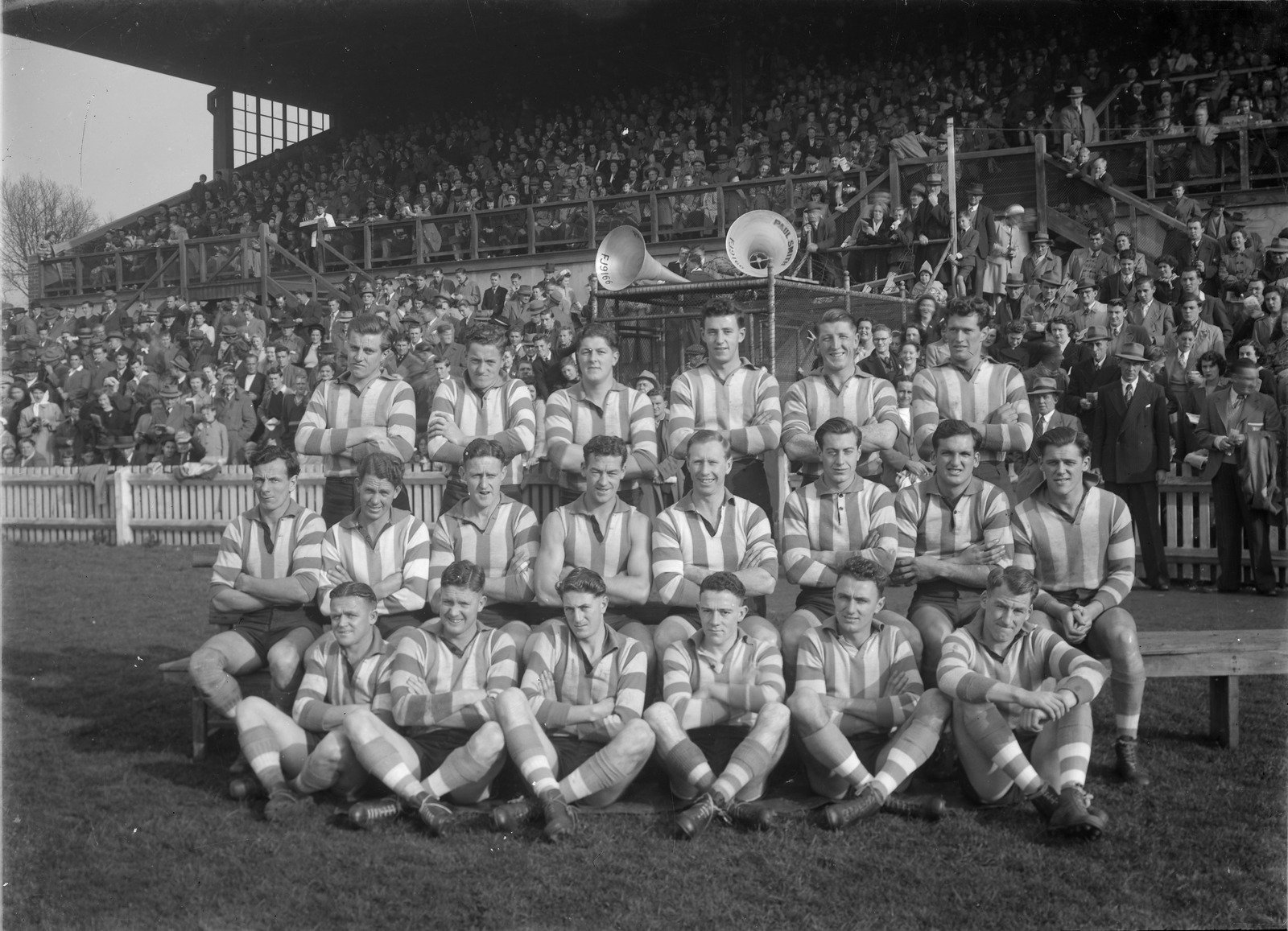 North Melbourne Football First Eighteen, (VFL) team in front of a grandstand 1949