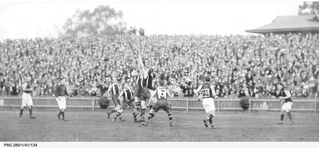 Large crowd of spectators watching a football match between the South Australian Second Eighteen (striped guernsey) and Tasmania at the Adelaide Oval held at the Adelaide Oval 21st July 1923