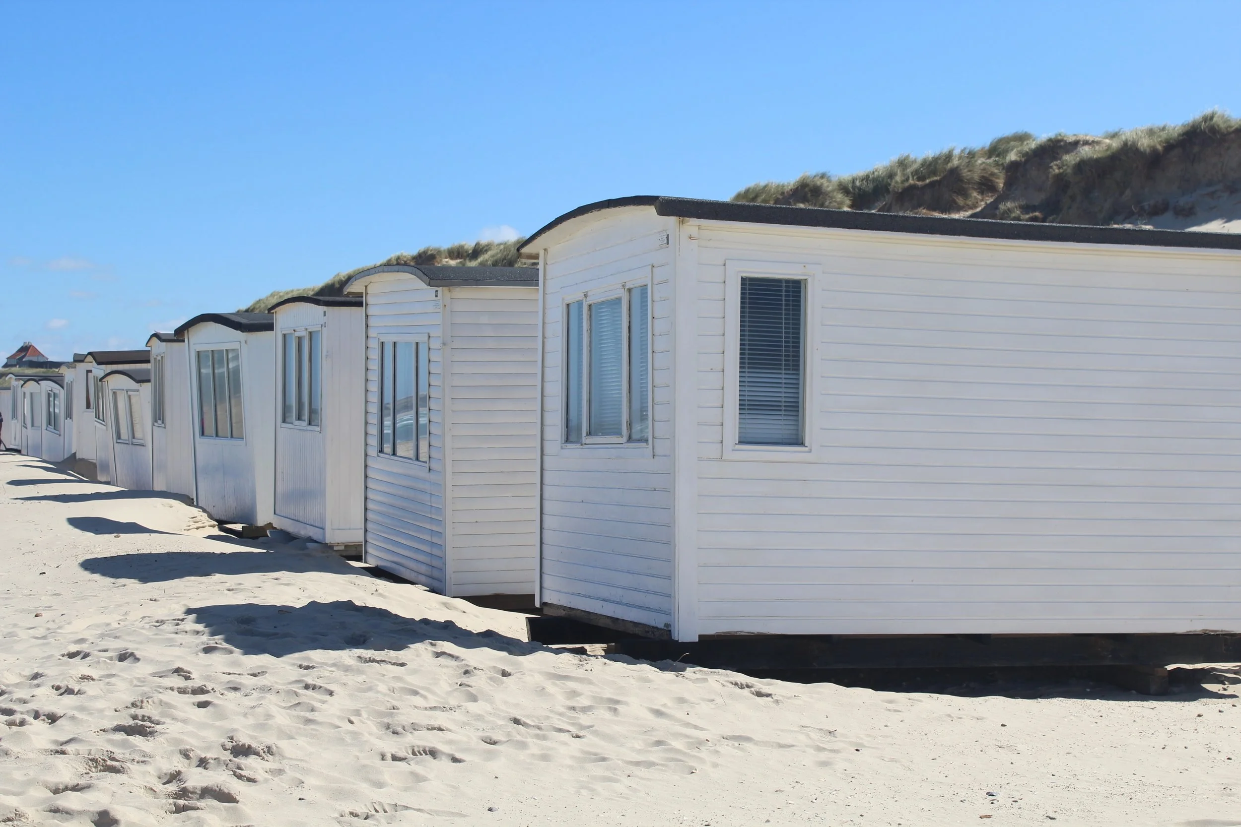 row of holiday homes on beach sand