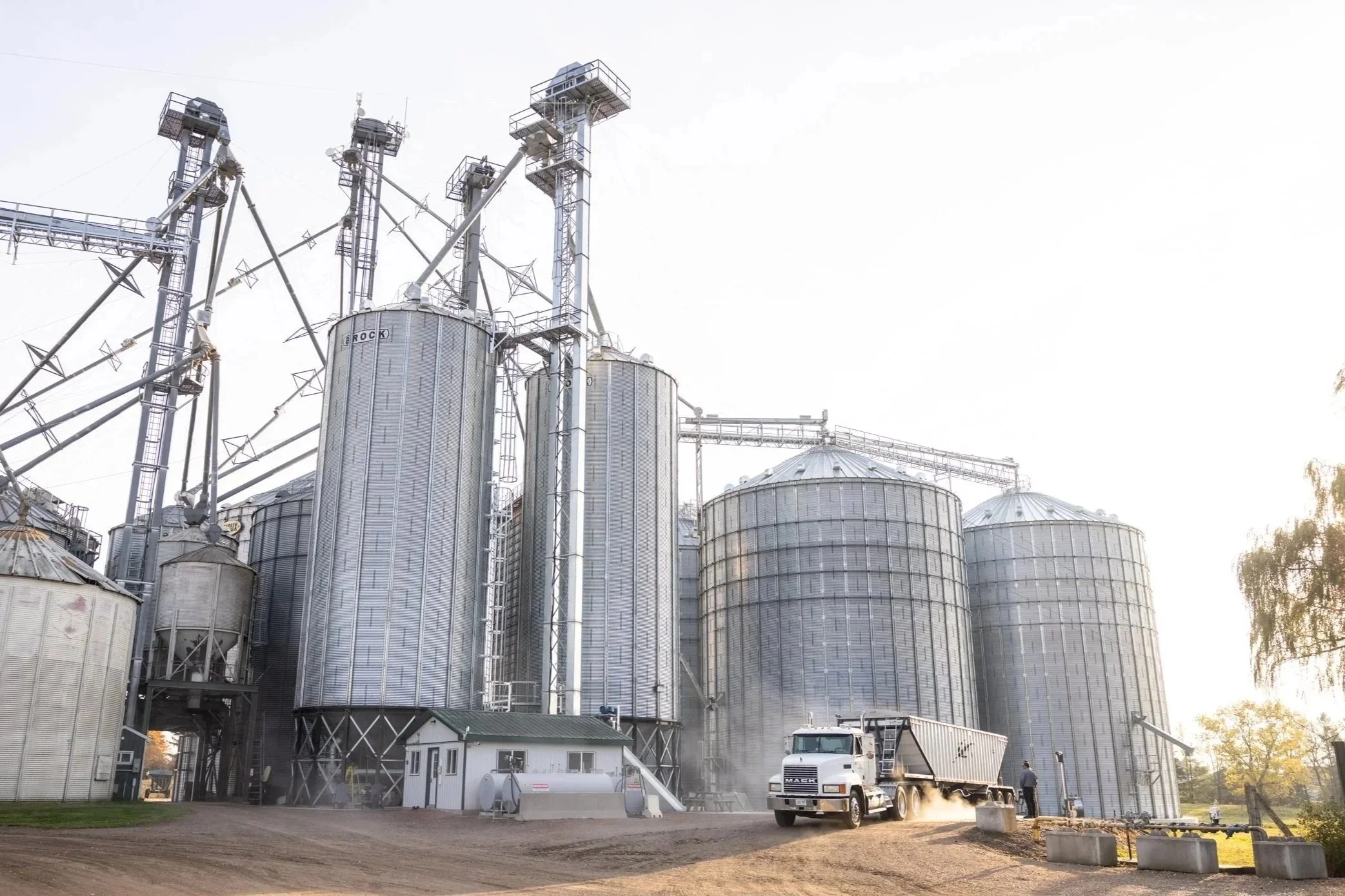 Grain elevator with bins and a grain truck unloading at a grain pit