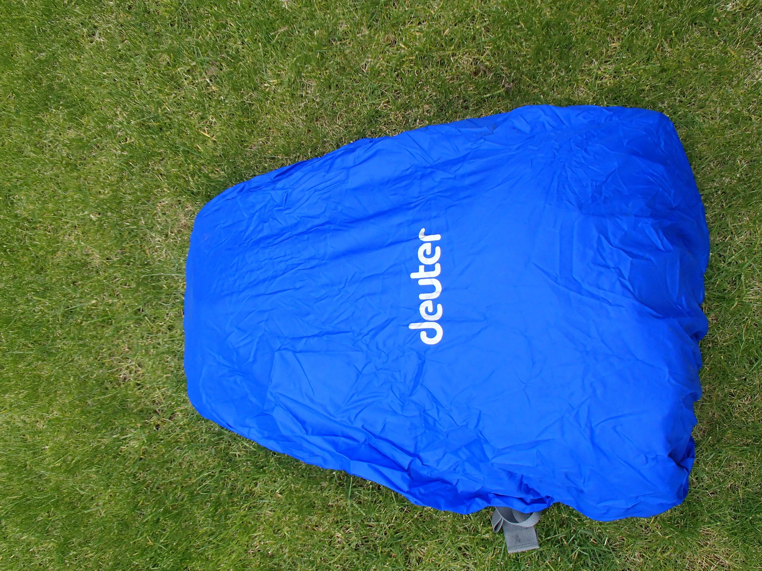 A walkers backpack or rucksack with a blue rain cover on it.