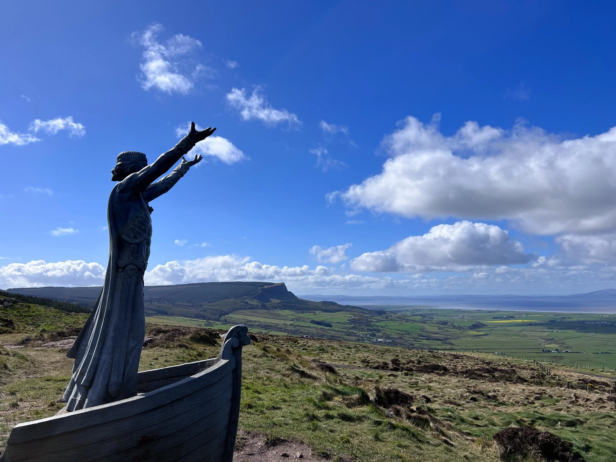The sculpture of Manannan Mac Lir at Gortmore Viewpoint in Northern Ireland, this is a statue of a sea god holding his hands up high over looking the view.