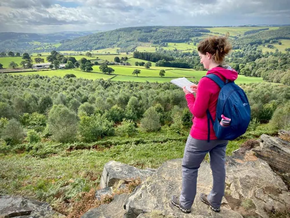 I lady holding a map in the Peak District on a navigation course