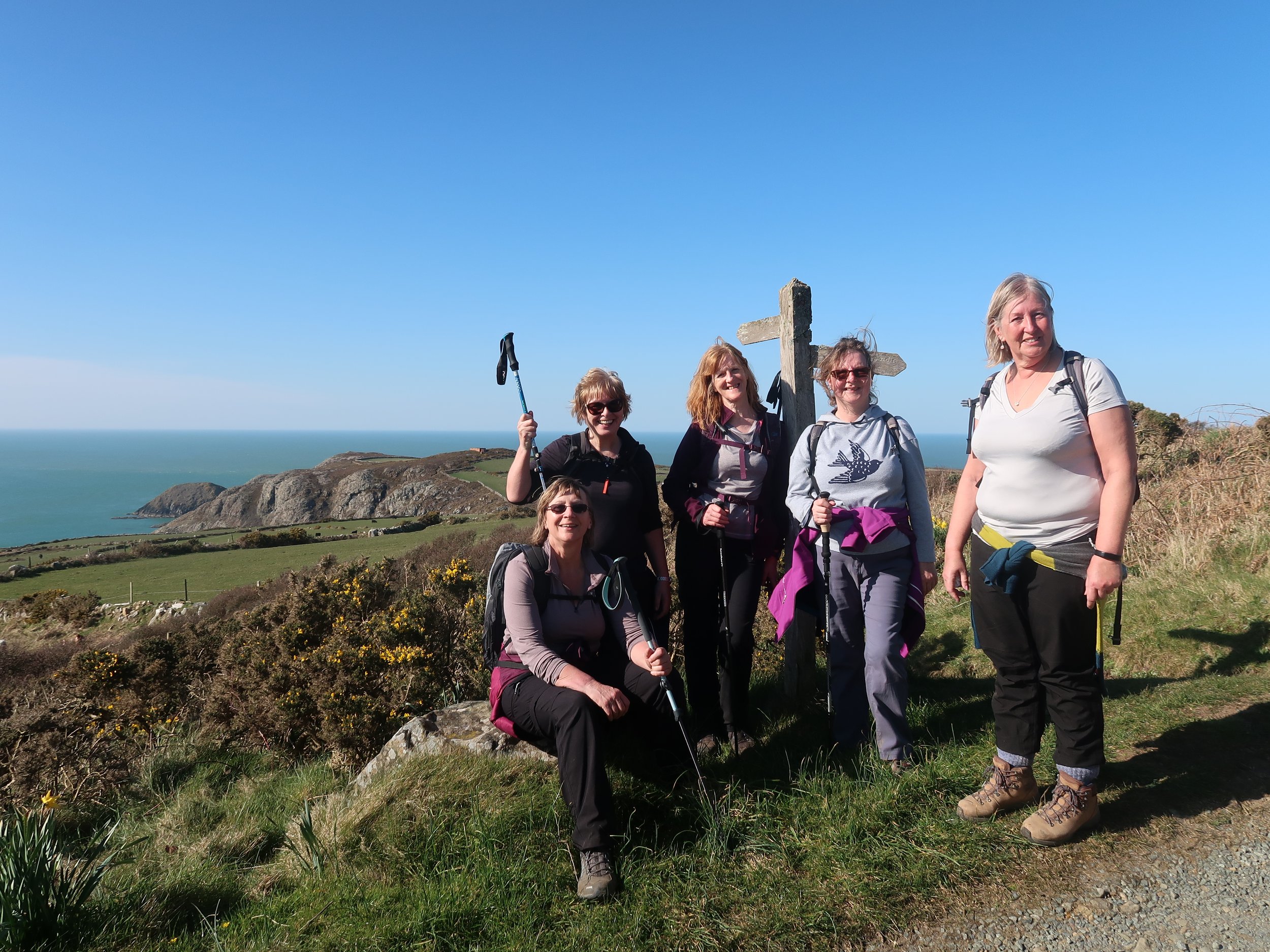 Group of women hikers posing on a coastal trail with ocean view