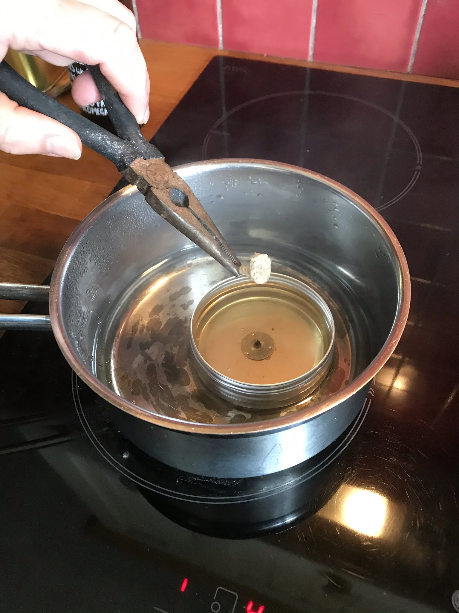 Floating wick being dipped in molten wax