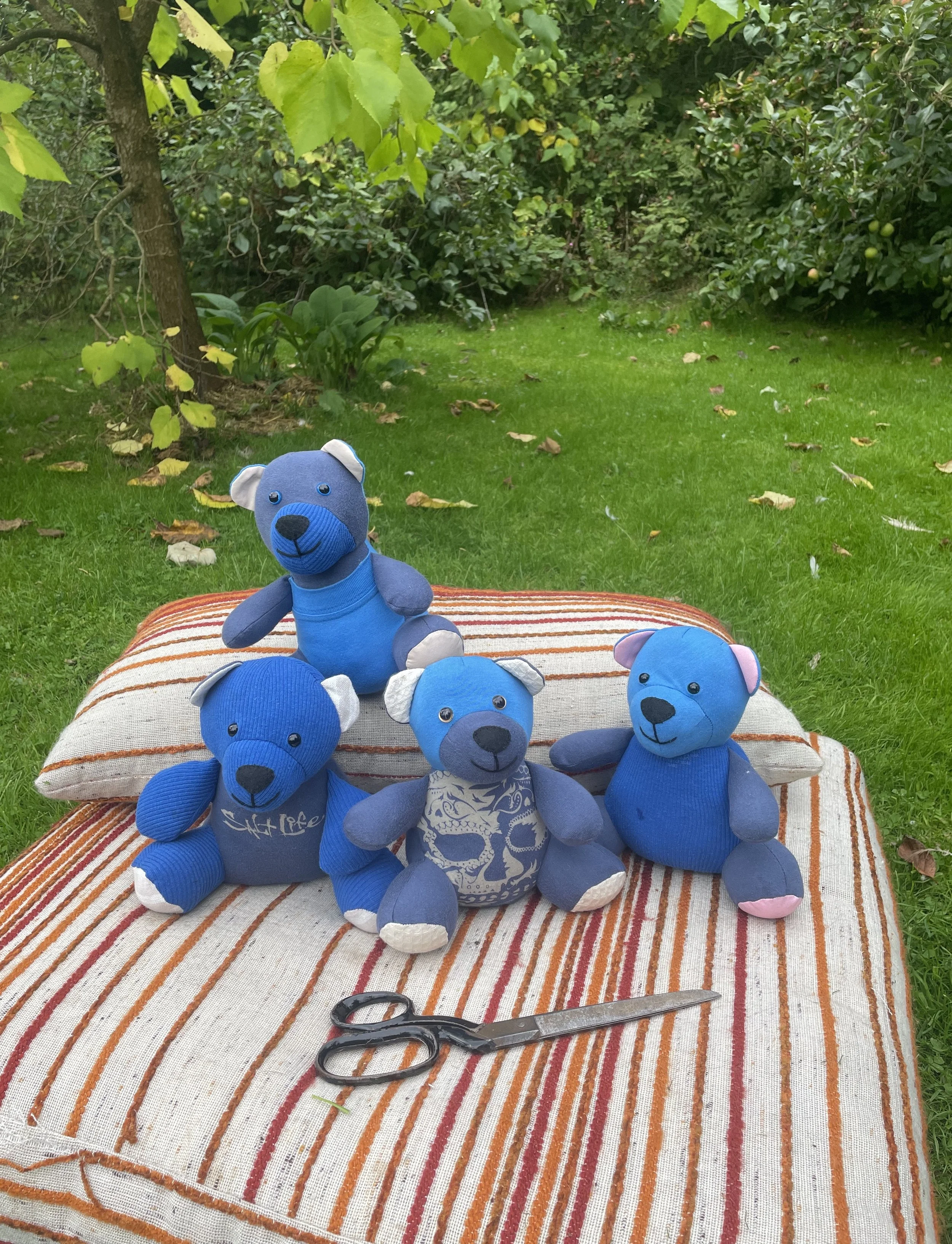 All the bears together outside, with sewing scissors for scale