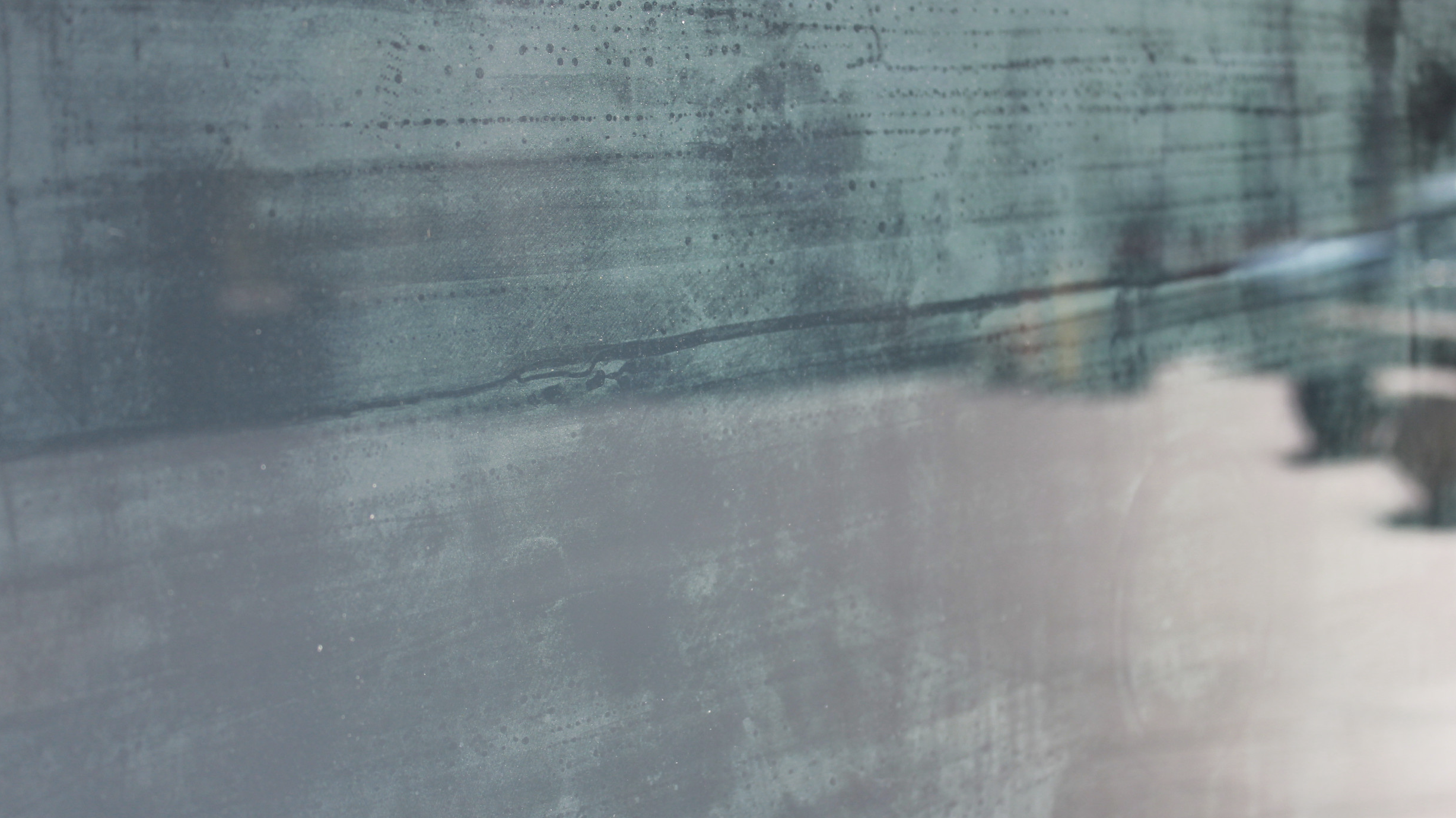 A close-up shot of condensation in a window, taken from outside on a sunny day.